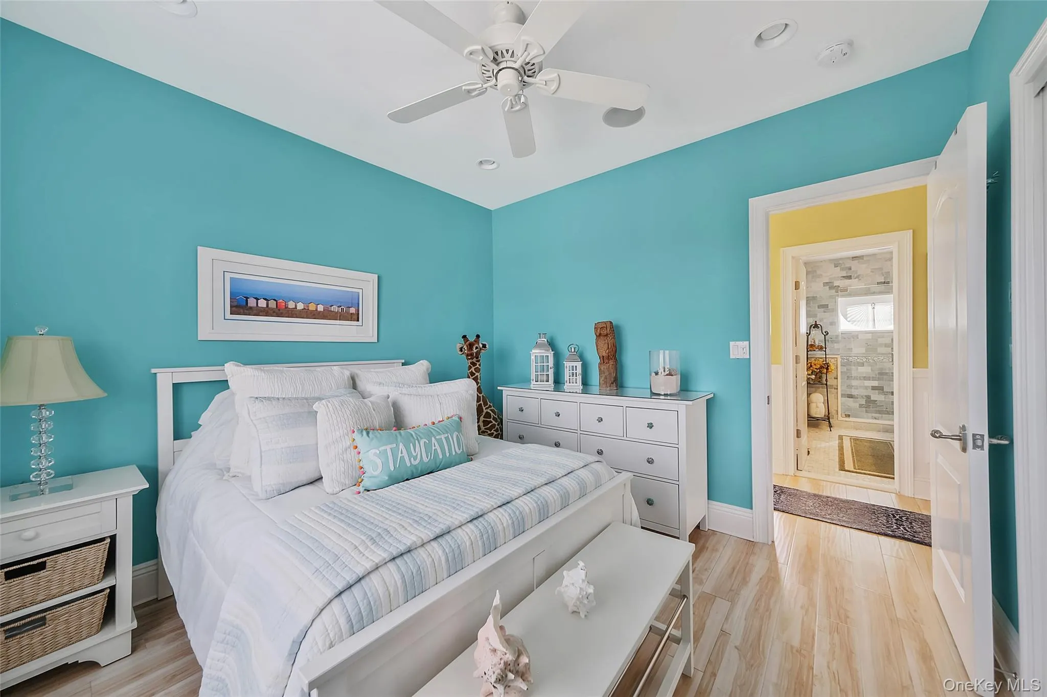 Bedroom featuring vibrant blue walls, wood-finish flooring, a white ceiling fan, and recessed lighting Bedroom featuring vibrant blue walls, wood-finish flooring, a white ceiling fan, and recessed lighting