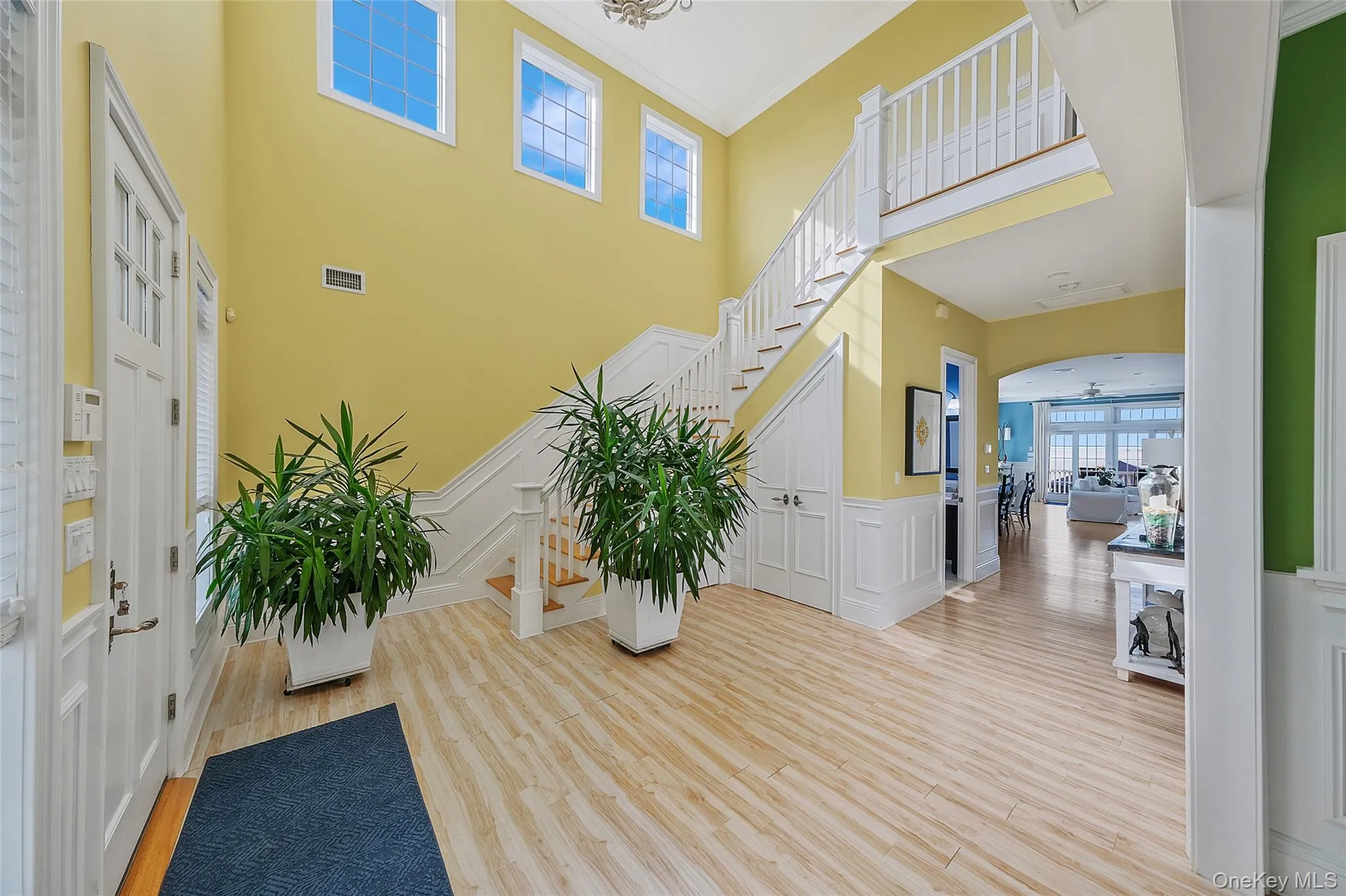 Grand entryway featuring a double-height ceiling and wood-finish flooring Grand entryway featuring a double-height ceiling and wood-finish flooring