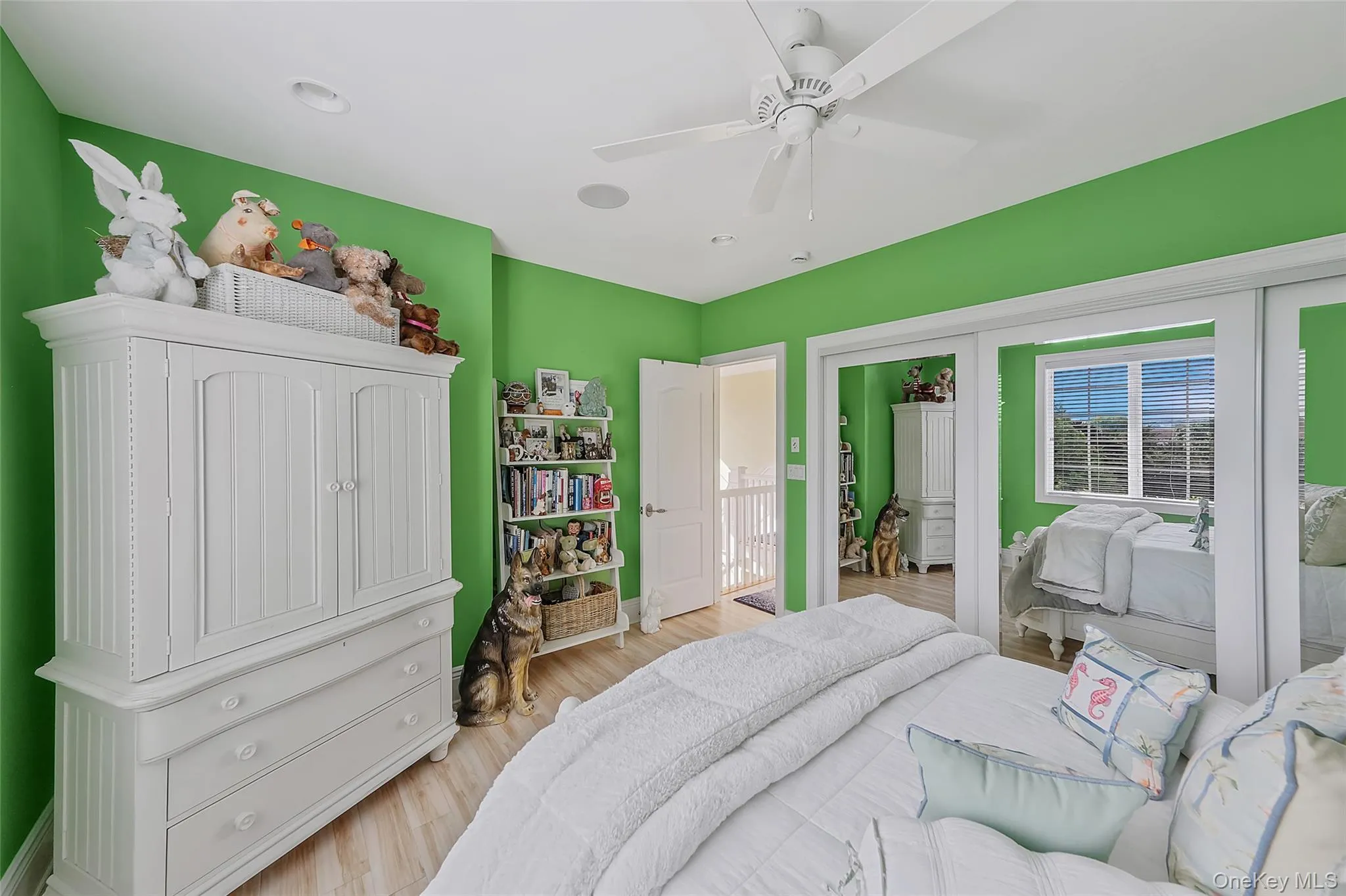 Bedroom featuring wood-finish flooring, a ceiling fan, recessed lighting, and a white interior door Bedroom featuring wood-finish flooring, a ceiling fan, recessed lighting, and a white interior door