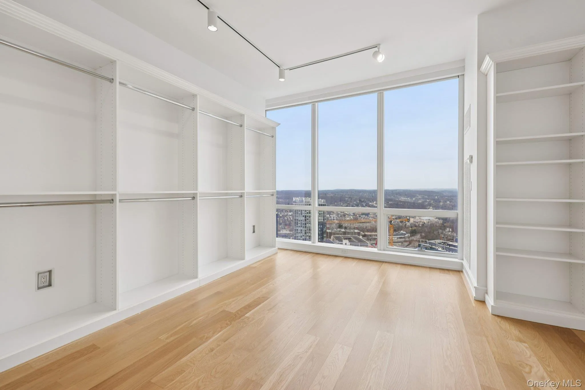 Walk in closet with light wood-style floors Walk in closet with light wood-style floors