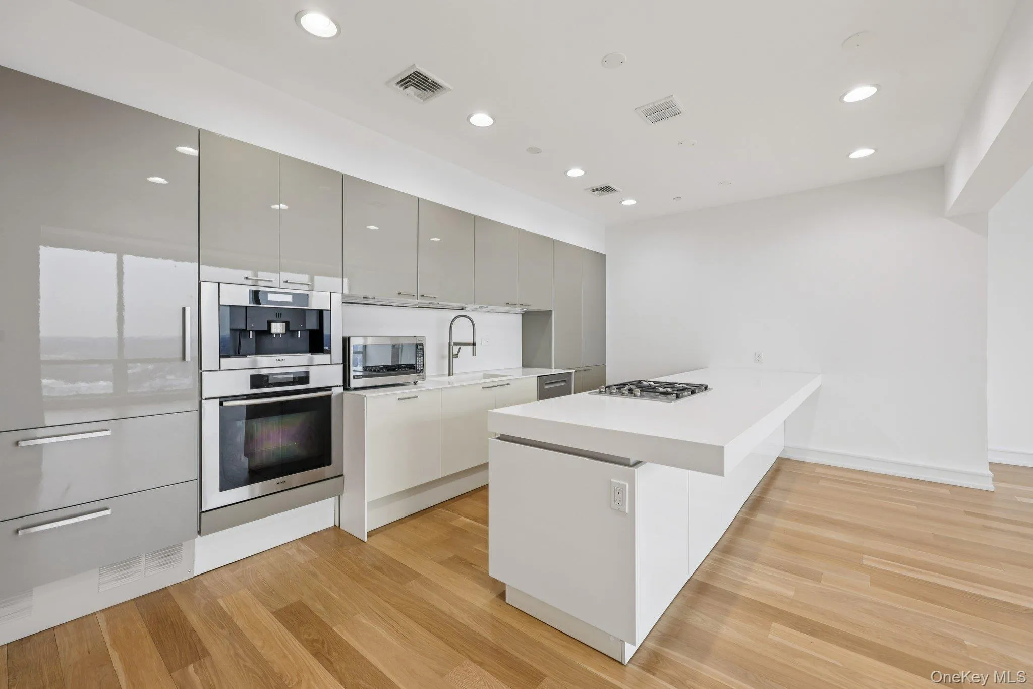 Kitchen with modern cabinets, a peninsula, appliances with stainless steel finishes, light wood-style flooring, and recessed lighting Kitchen with modern cabinets, a peninsula, appliances with stainless steel finishes, light wood-style flooring, and recessed lighting