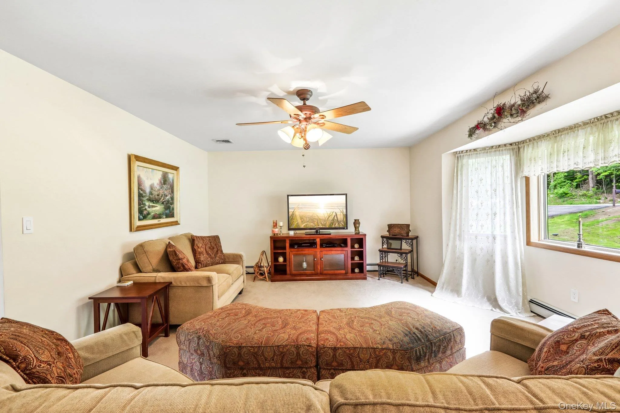 Living room with lots of natural light, carpeting and a ceiling fan. Living room with lots of natural light, carpeting and a ceiling fan.