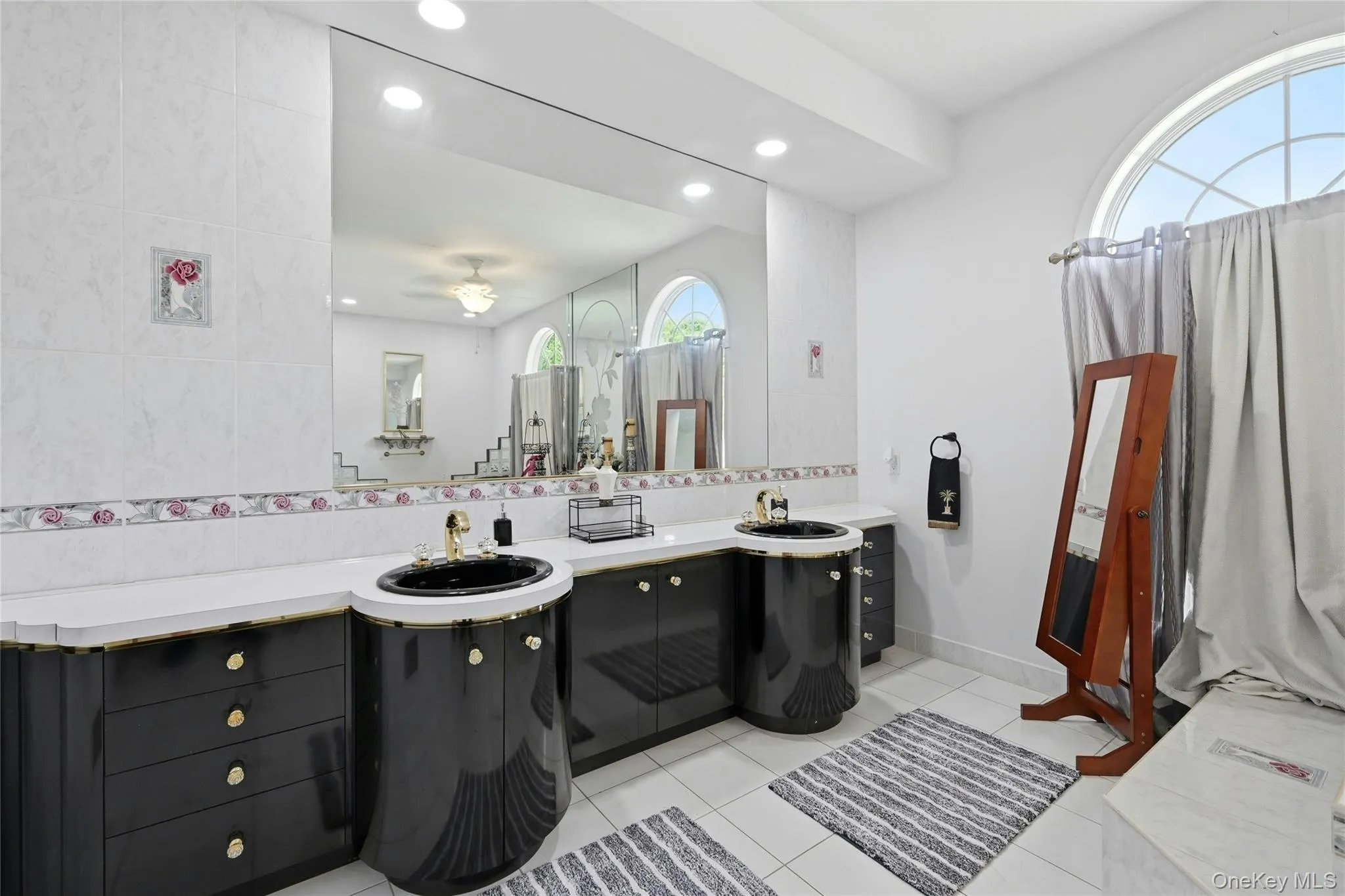 Dual black vanity sinks with gold-tone fixtures set in a white countertop Dual black vanity sinks with gold-tone fixtures set in a white countertop