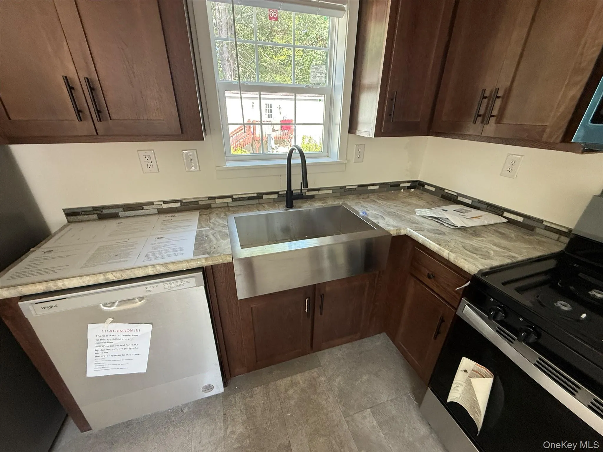 Kitchen featuring black range oven, stainless steel dishwasher, and dark brown cabinets Kitchen featuring black range oven, stainless steel dishwasher, and dark brown cabinets