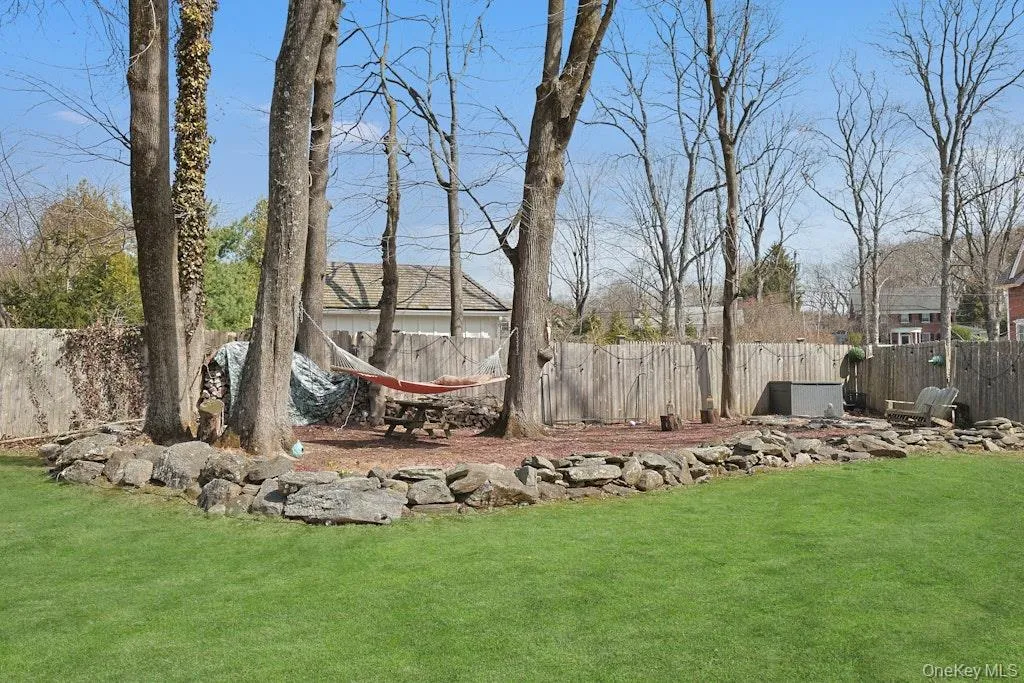 Inviting backyard area with firepit seating and hammock Inviting backyard area with firepit seating and hammock