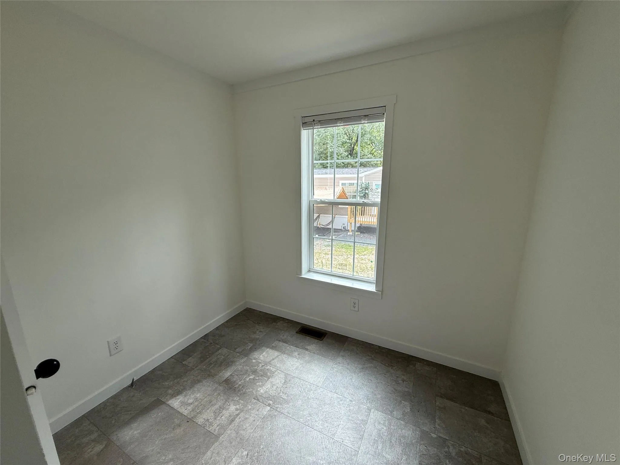 Spare room featuring light stone finish floors and baseboards Spare room featuring light stone finish floors and baseboards