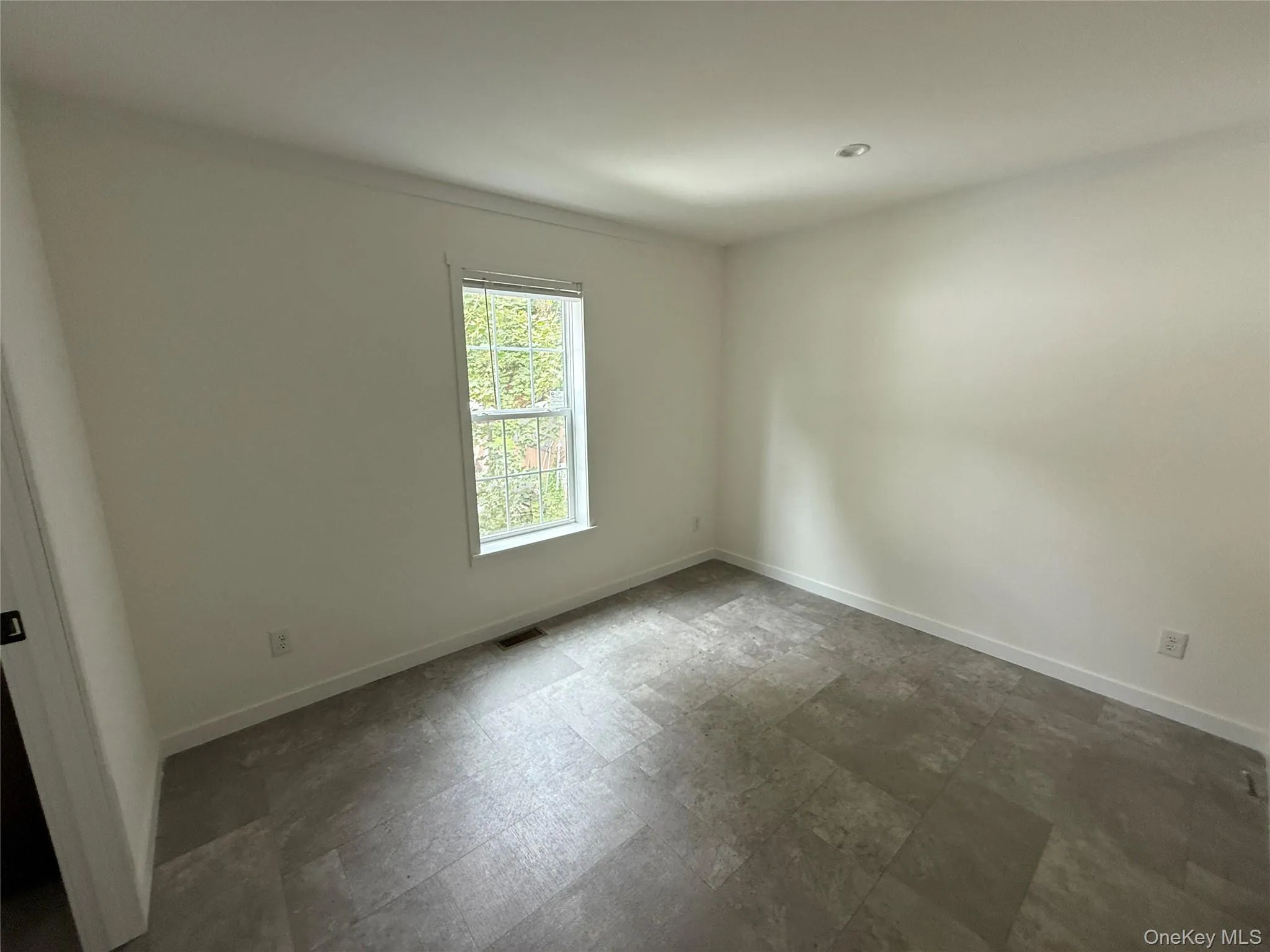 Empty room featuring baseboards and stone finish flooring Empty room featuring baseboards and stone finish flooring