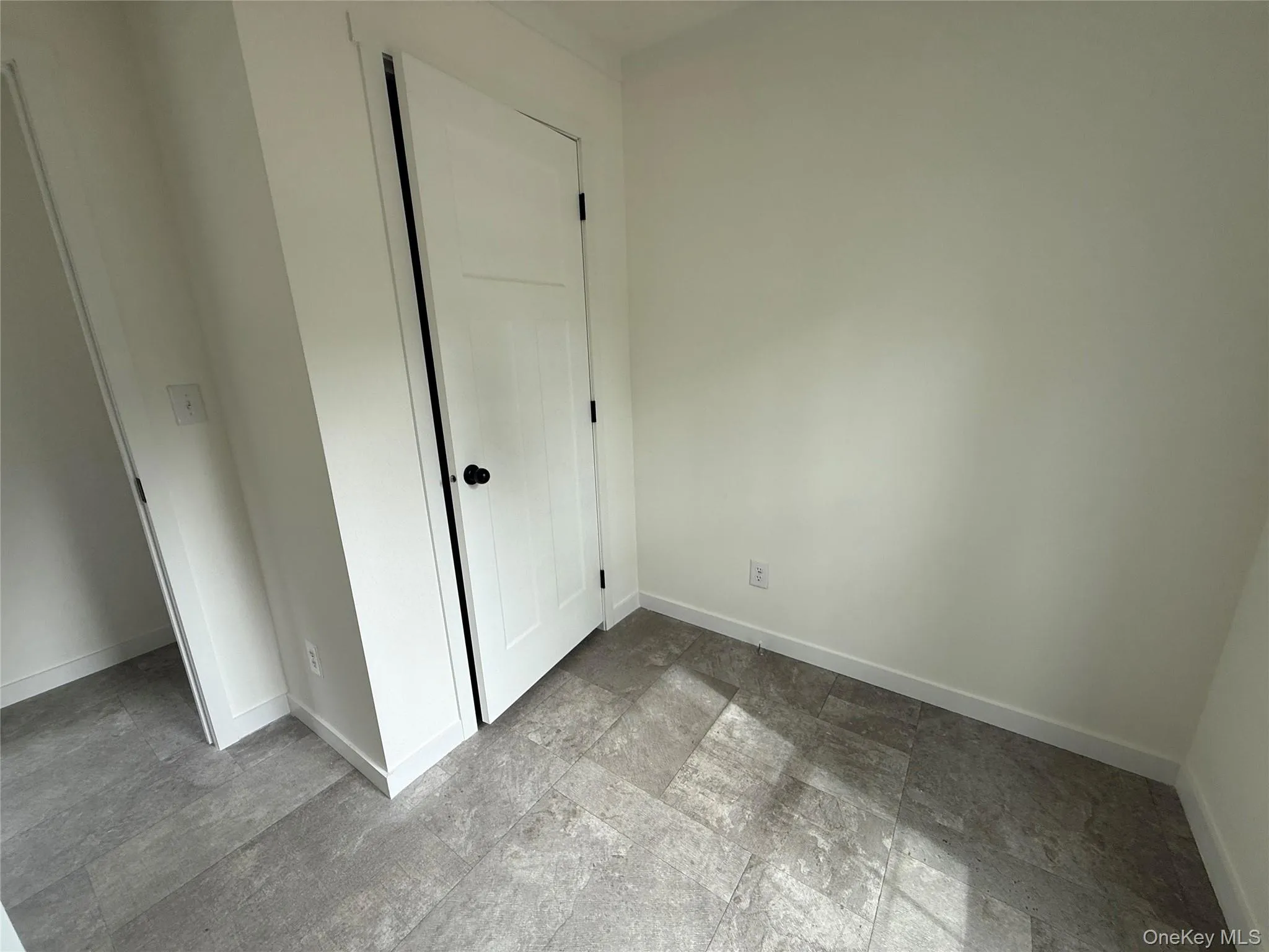 Unfurnished bedroom featuring baseboards and stone finish flooring Unfurnished bedroom featuring baseboards and stone finish flooring