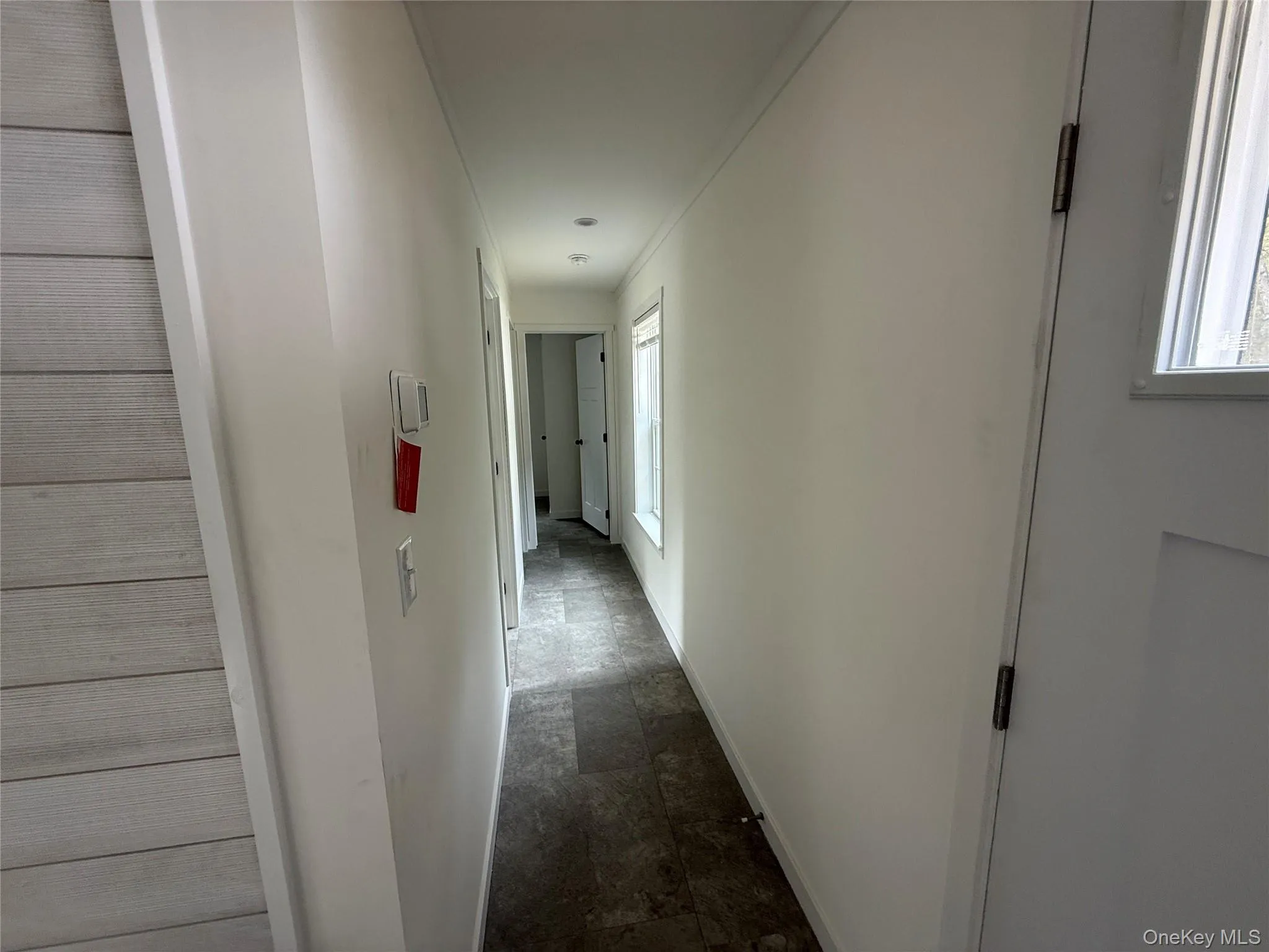 Hall with stone finish flooring and baseboards Hall with stone finish flooring and baseboards