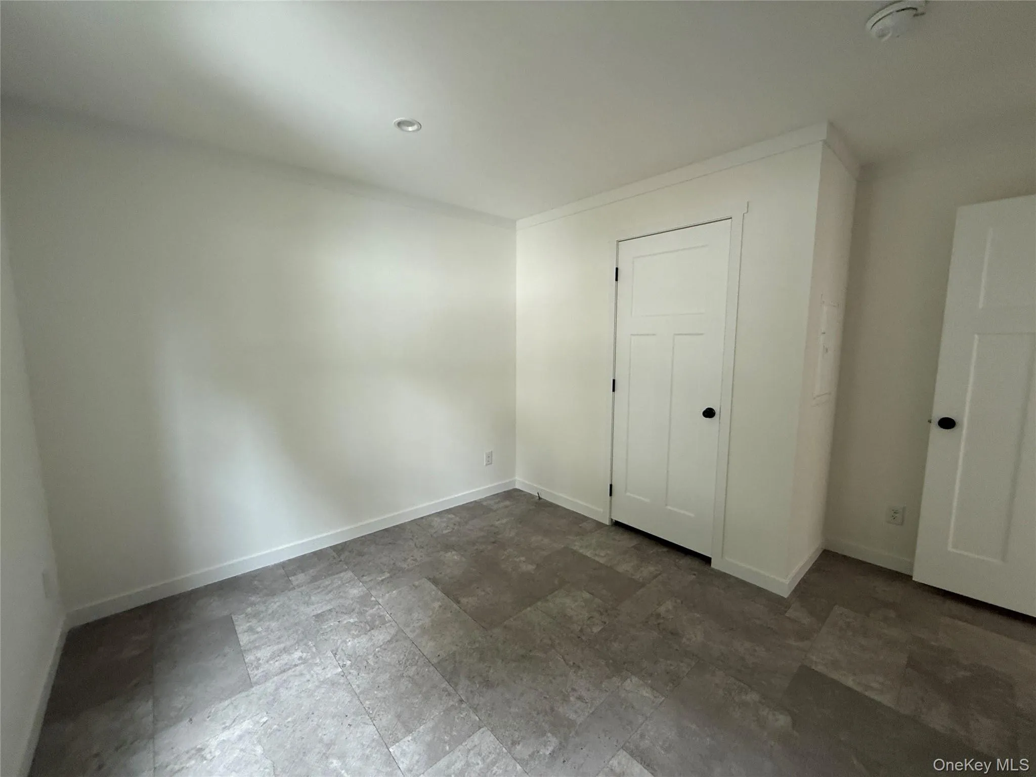 Unfurnished bedroom featuring dark stone finish flooring and recessed lighting Unfurnished bedroom featuring dark stone finish flooring and recessed lighting