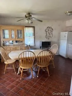 Dining area featuring ceramic tile flooring, a window with natural light, and a ceiling fan with integrated lighting Dining area featuring ceramic tile flooring, a window with natural light, and a ceiling fan with integrated lighting