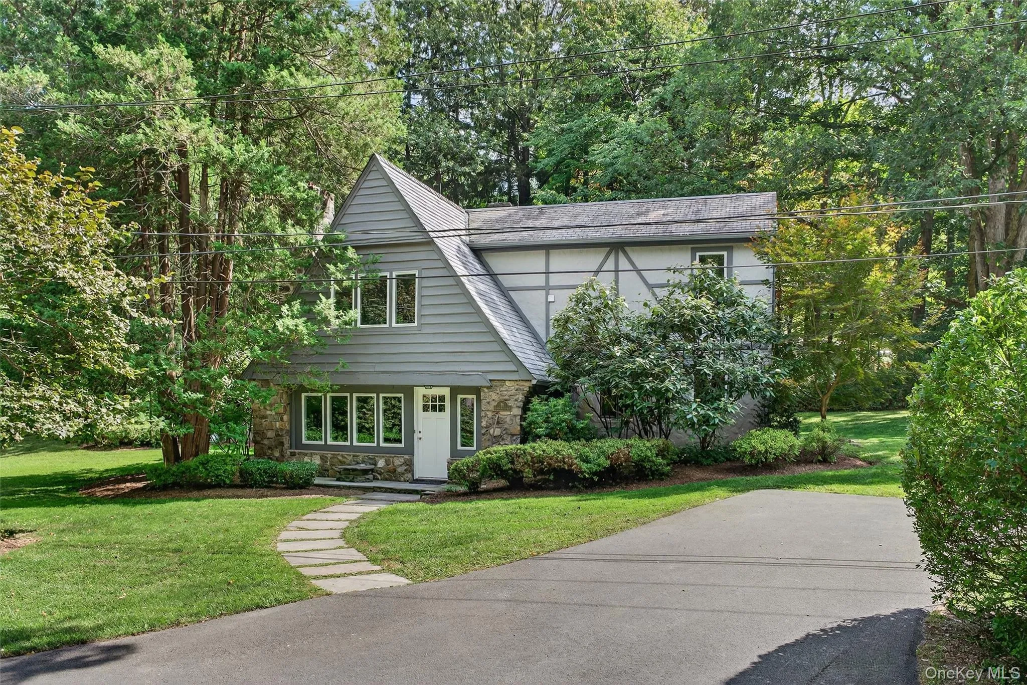 Large front yard with extensive driveway parking and view of wooded area Large front yard with extensive driveway parking and view of wooded area