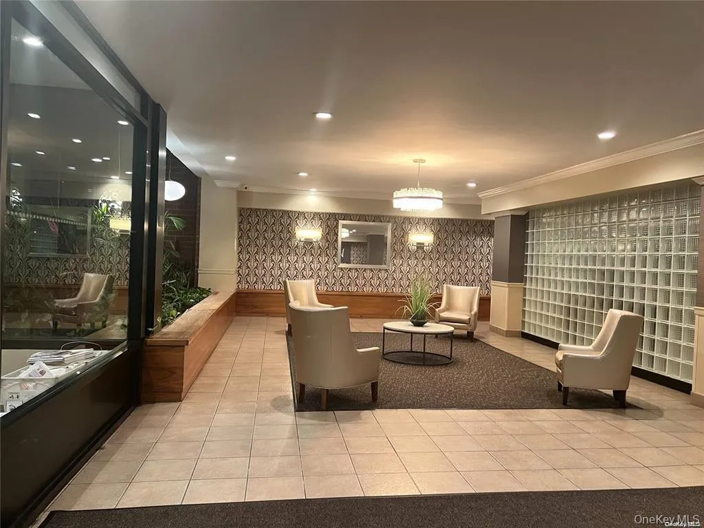 Building lobby with wallpapered walls, ornamental molding, and recessed lighting Building lobby with wallpapered walls, ornamental molding, and recessed lighting