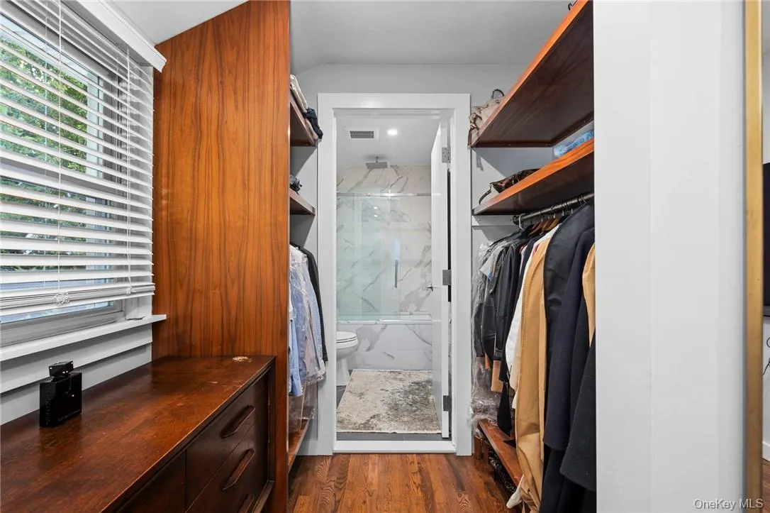 Walk in closet featuring dark hardwood / wood-style floors Walk in closet featuring dark hardwood / wood-style floors