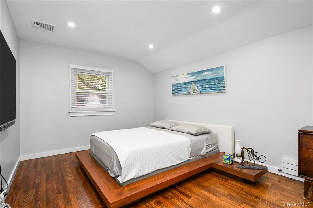 Bedroom featuring hardwood / wood-style flooring and lofted ceiling Bedroom featuring hardwood / wood-style flooring and lofted ceiling