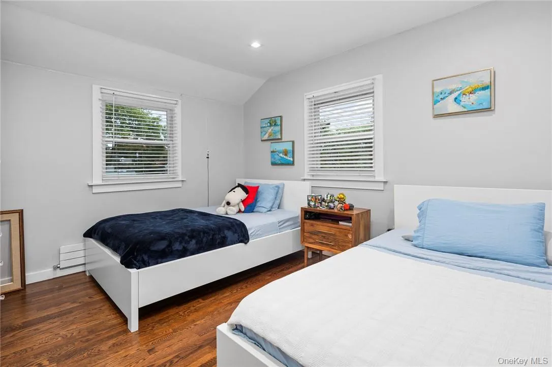 Bedroom with lofted ceiling and dark hardwood / wood-style flooring Bedroom with lofted ceiling and dark hardwood / wood-style flooring