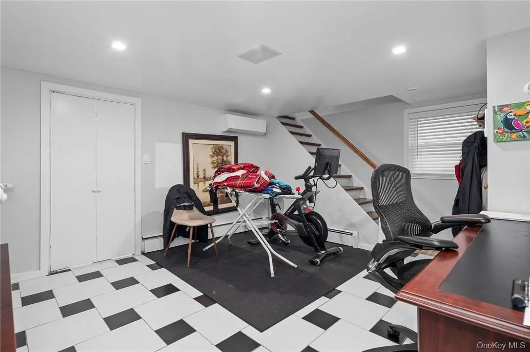 Workout area with baseboard heating and an AC wall unit Workout area with baseboard heating and an AC wall unit