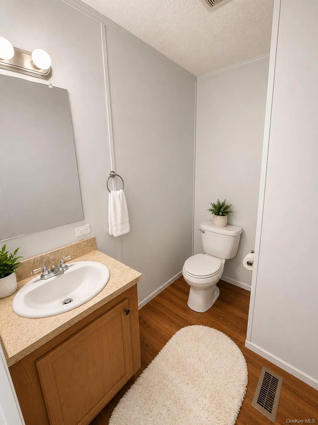 Bathroom vanity with a light wood-finish cabinet, speckled countertop, and oval undermount sink Bathroom vanity with a light wood-finish cabinet, speckled countertop, and oval undermount sink