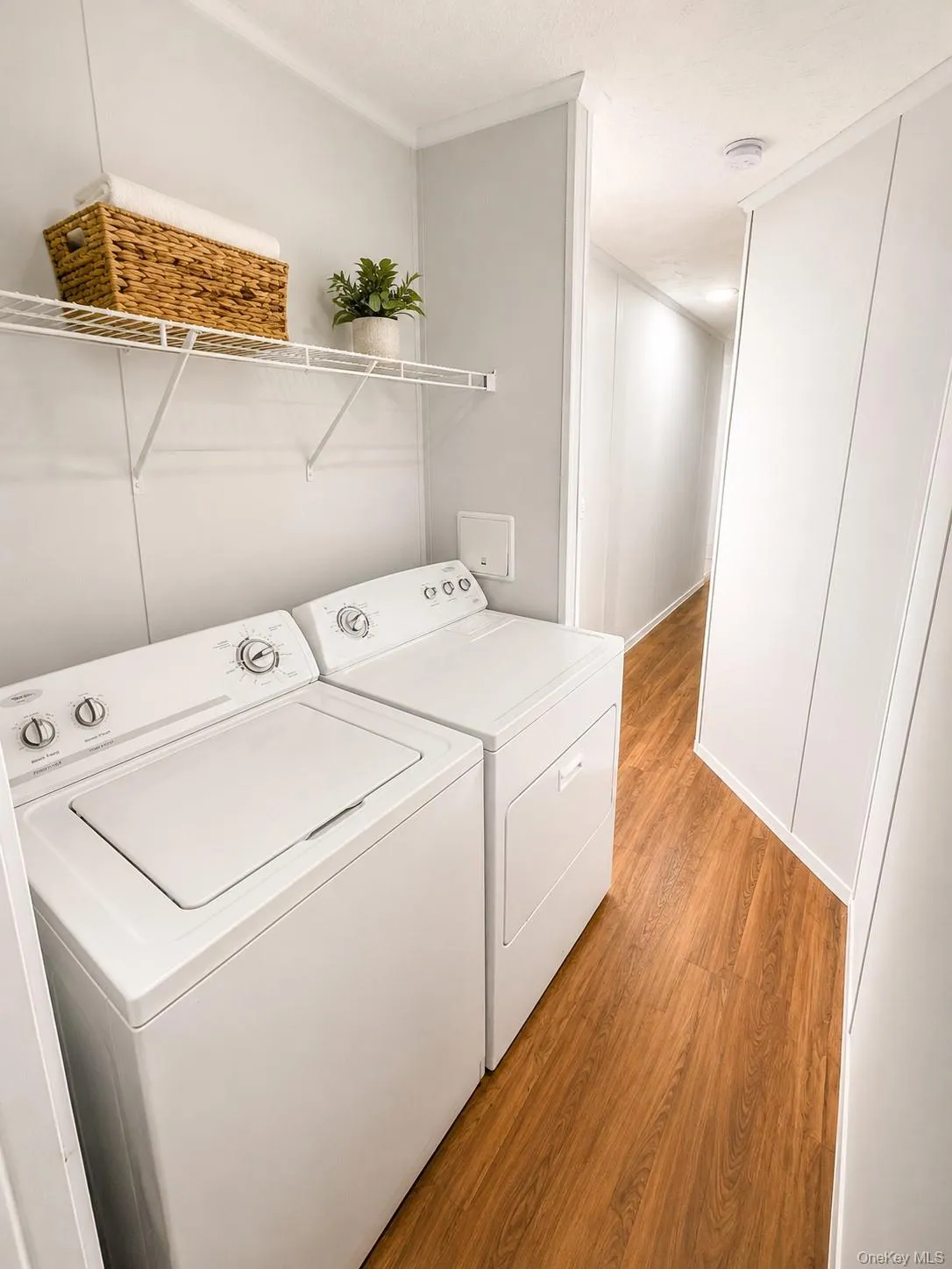 Dedicated laundry area featuring a washer and dryer, wood-finish flooring Dedicated laundry area featuring a washer and dryer, wood-finish flooring