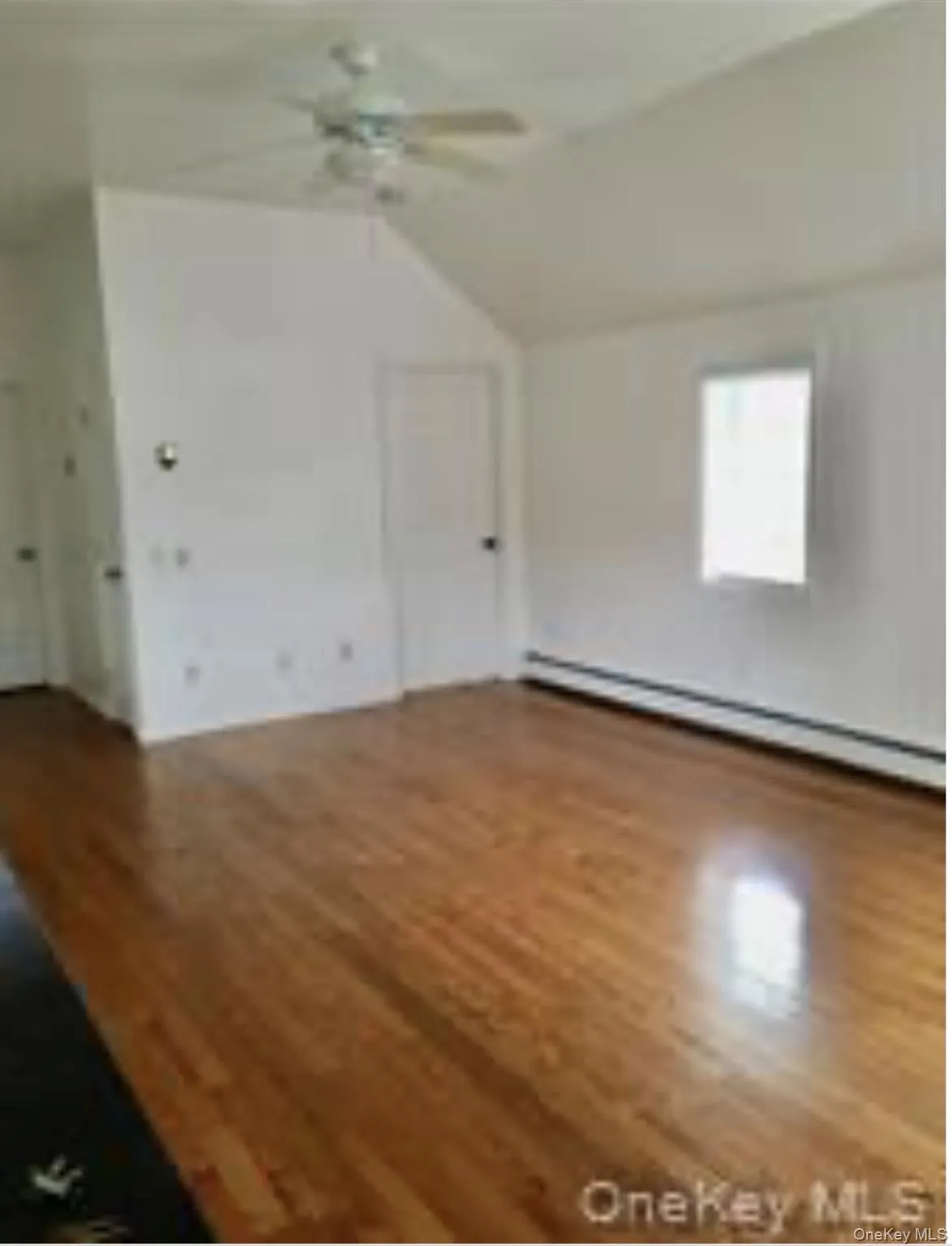 Main living space, door to smaller bedroom with cathedral ceilings Main living space, door to smaller bedroom with cathedral ceilings