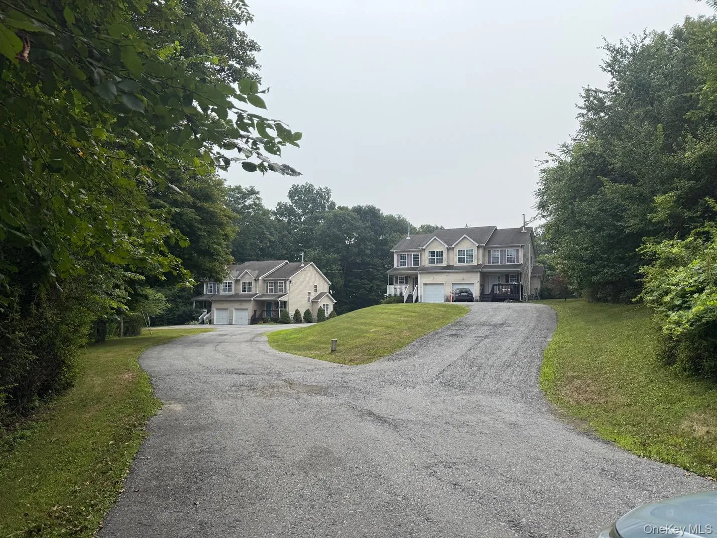 Very private community featuring two separate duplexes. Shows the view front of property featuring asphalt driveway, garages, and a front lawn Very private community featuring two separate duplexes. Shows the view front of property featuring asphalt driveway, garages, and a front lawn