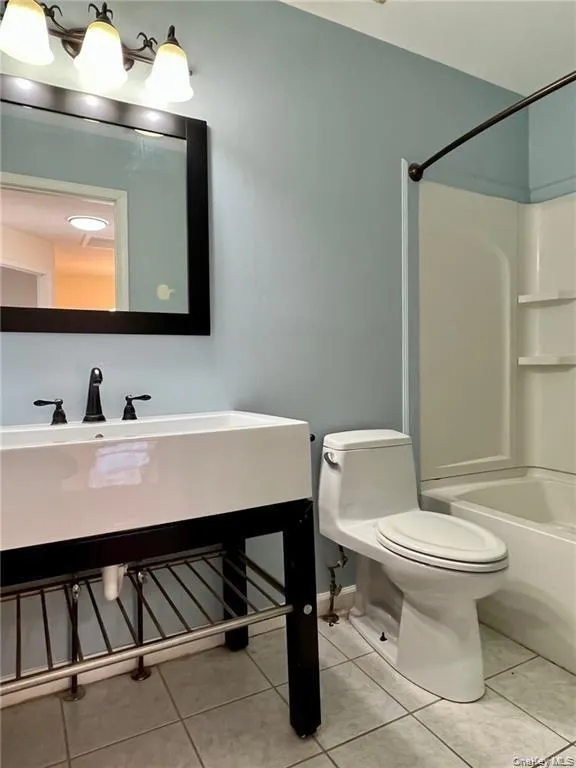 Full hall bathroom featuring shower / bathtub combination, tile floors, vanity, and toilet Full hall bathroom featuring shower / bathtub combination, tile floors, vanity, and toilet