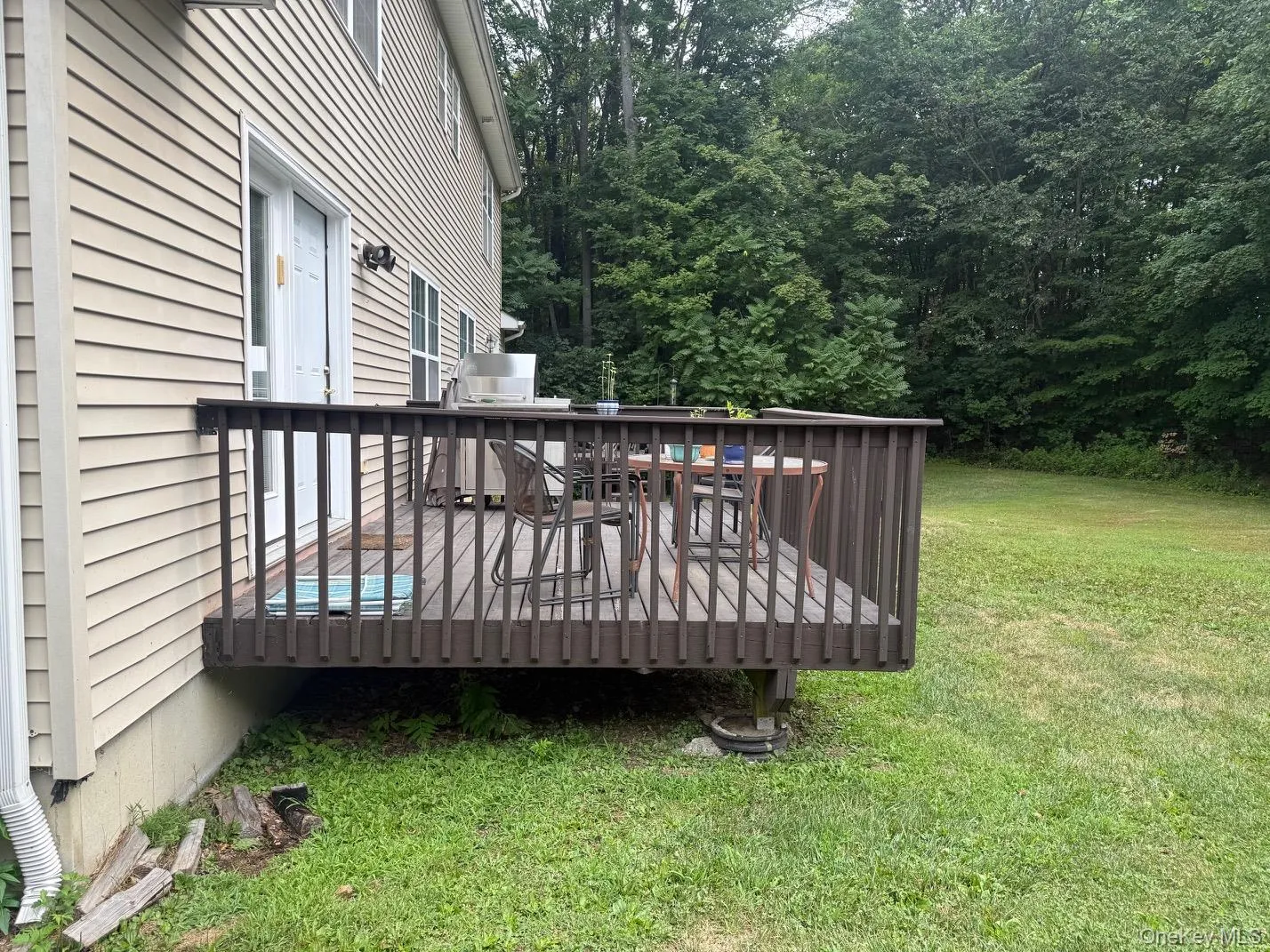Wooden deck with a yard and area for grilling Wooden deck with a yard and area for grilling