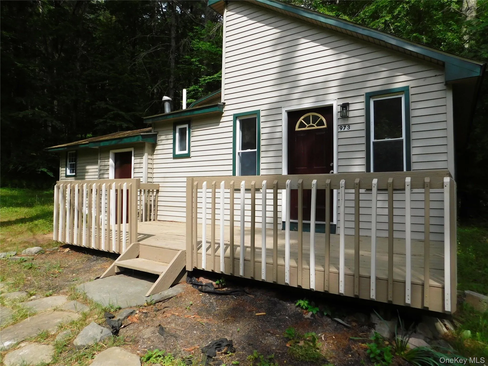 Exterior featuring light-colored horizontal siding and dark green trim accents showing deck Exterior featuring light-colored horizontal siding and dark green trim accents showing deck