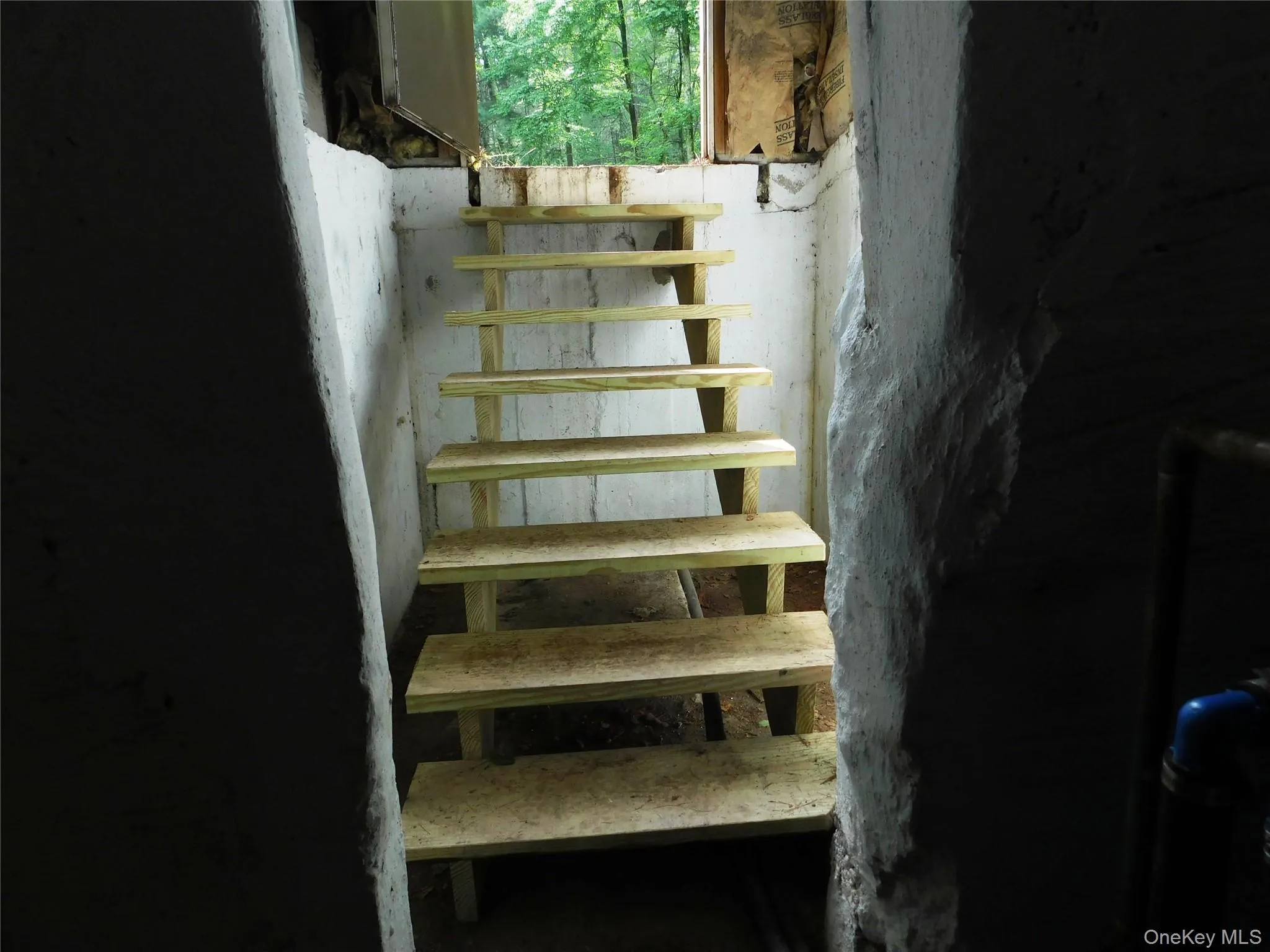 Unfinished wooden staircase providing access to the exterior Unfinished wooden staircase providing access to the exterior