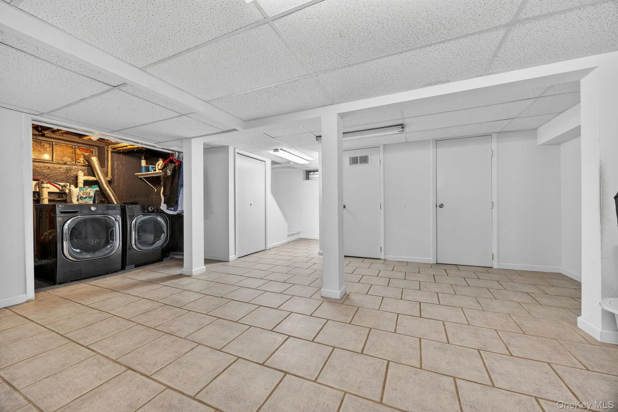 Spacious, featuring tile flooring, drop ceiling, and multiple storage closets, washer/dryer Spacious, featuring tile flooring, drop ceiling, and multiple storage closets, washer/dryer