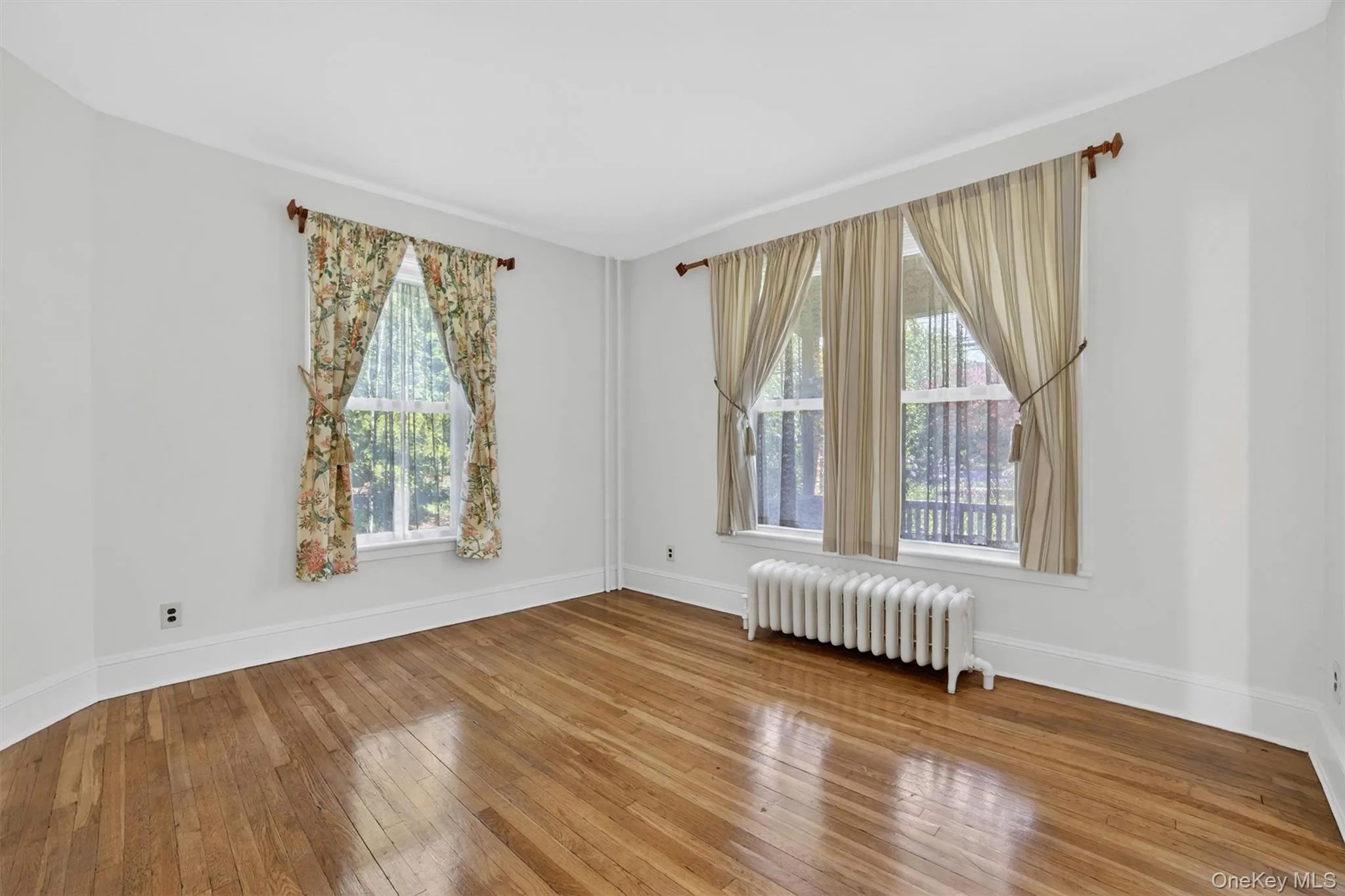 Sunny and bright living room with beautiful hardwood flooring. Sunny and bright living room with beautiful hardwood flooring.