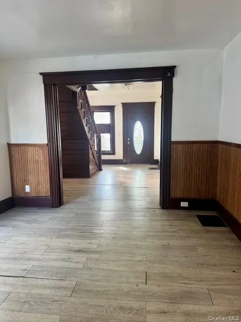 Wood-finish flooring throughout, featuring a broad entryway with dark wood trim Wood-finish flooring throughout, featuring a broad entryway with dark wood trim
