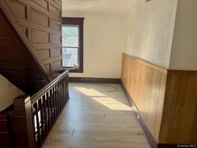 Staircase with paneled wood detailing, turned balusters, and a rich wood-tone handrail Staircase with paneled wood detailing, turned balusters, and a rich wood-tone handrail
