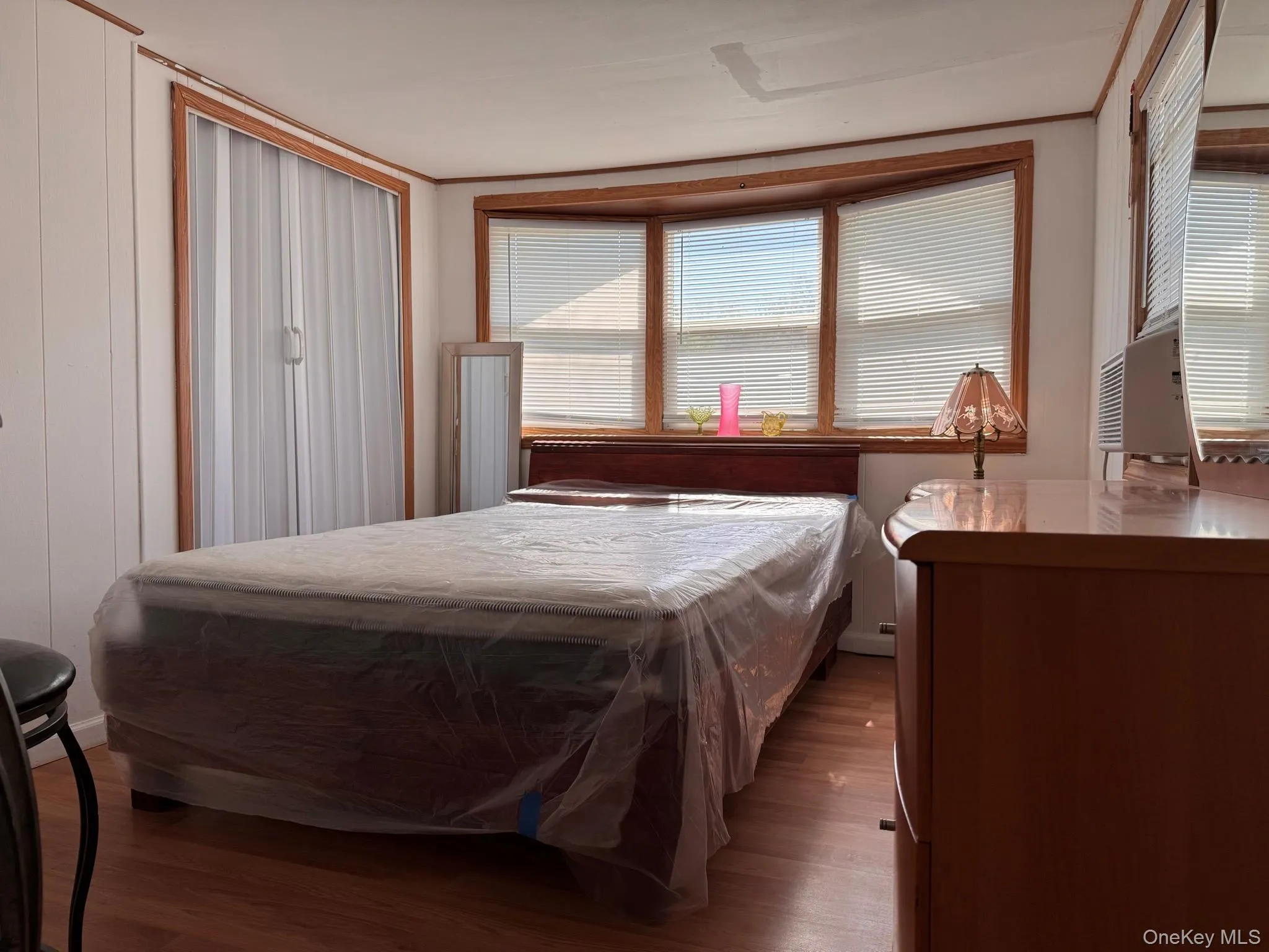 Room featuring wood-finish flooring and white walls with wood trim Room featuring wood-finish flooring and white walls with wood trim