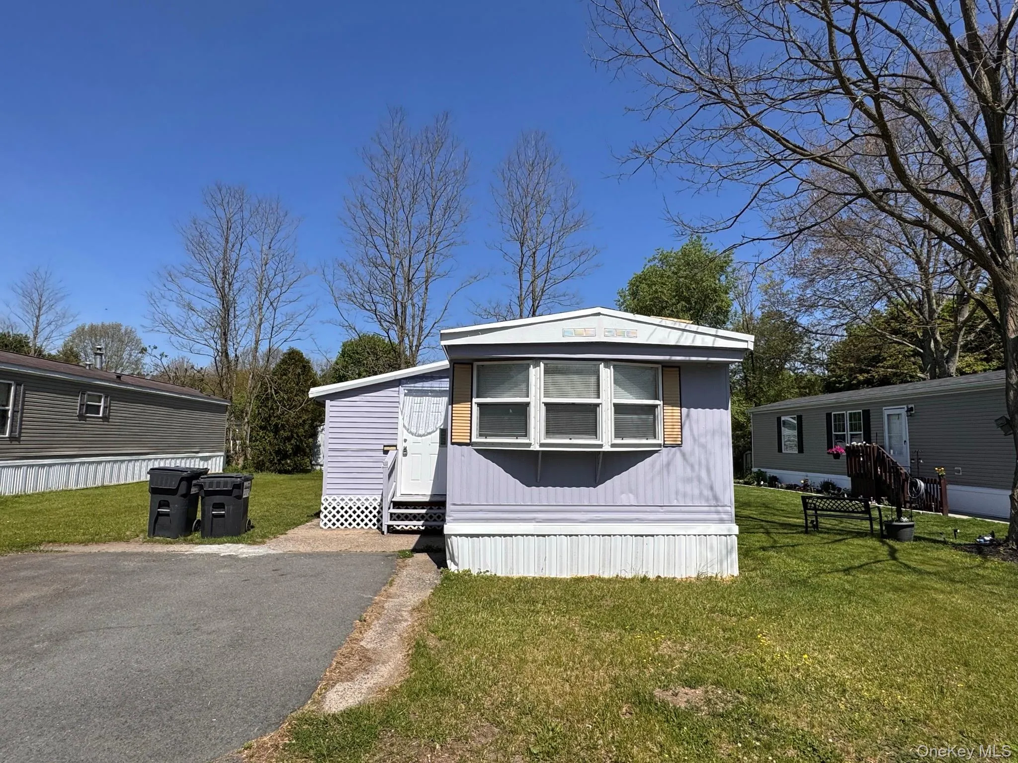 Single-story residence featuring light purple siding and white trim Single-story residence featuring light purple siding and white trim