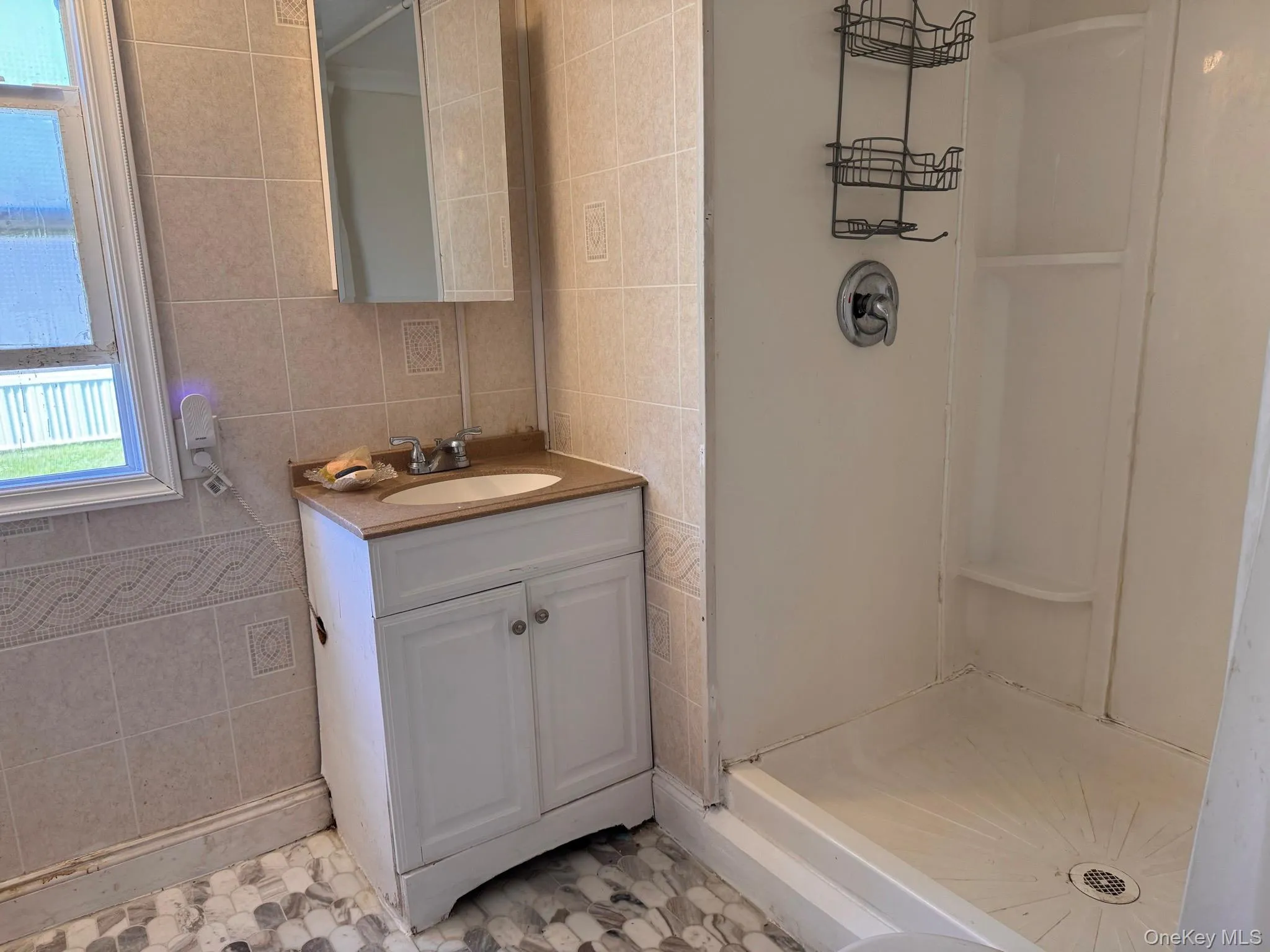 Bathroom featuring a single vanity, a recessed medicine cabinet with mirrored door, and a walk-in shower Bathroom featuring a single vanity, a recessed medicine cabinet with mirrored door, and a walk-in shower