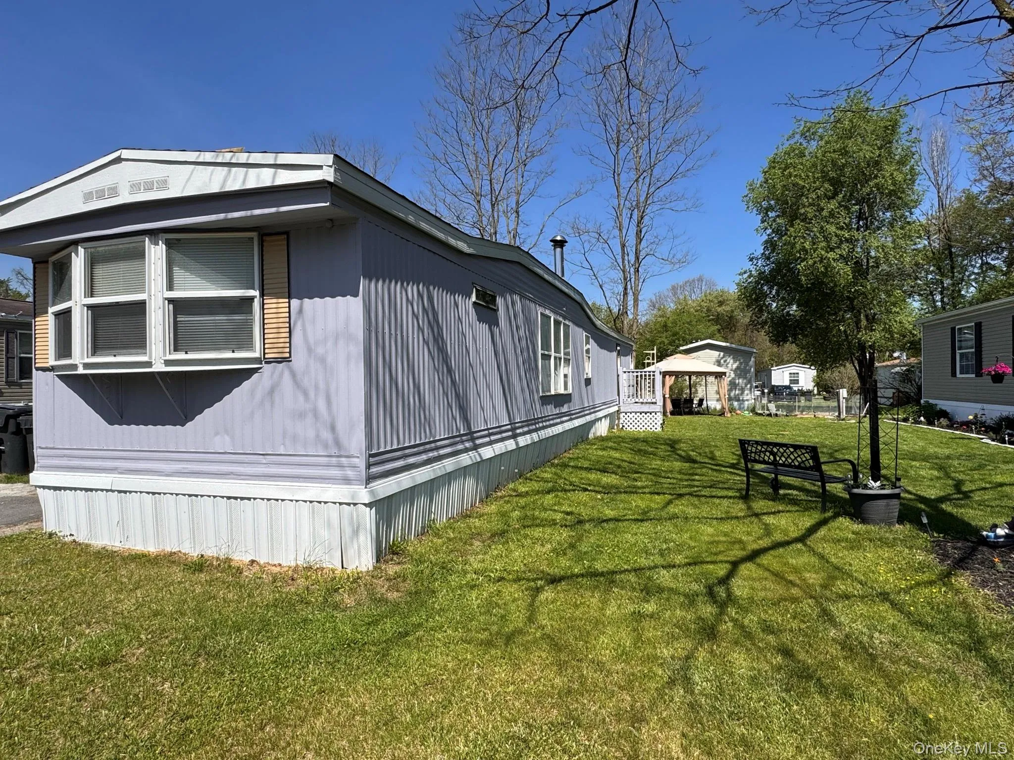 Pale blue siding exterior with white trim and a prominent bay window Pale blue siding exterior with white trim and a prominent bay window