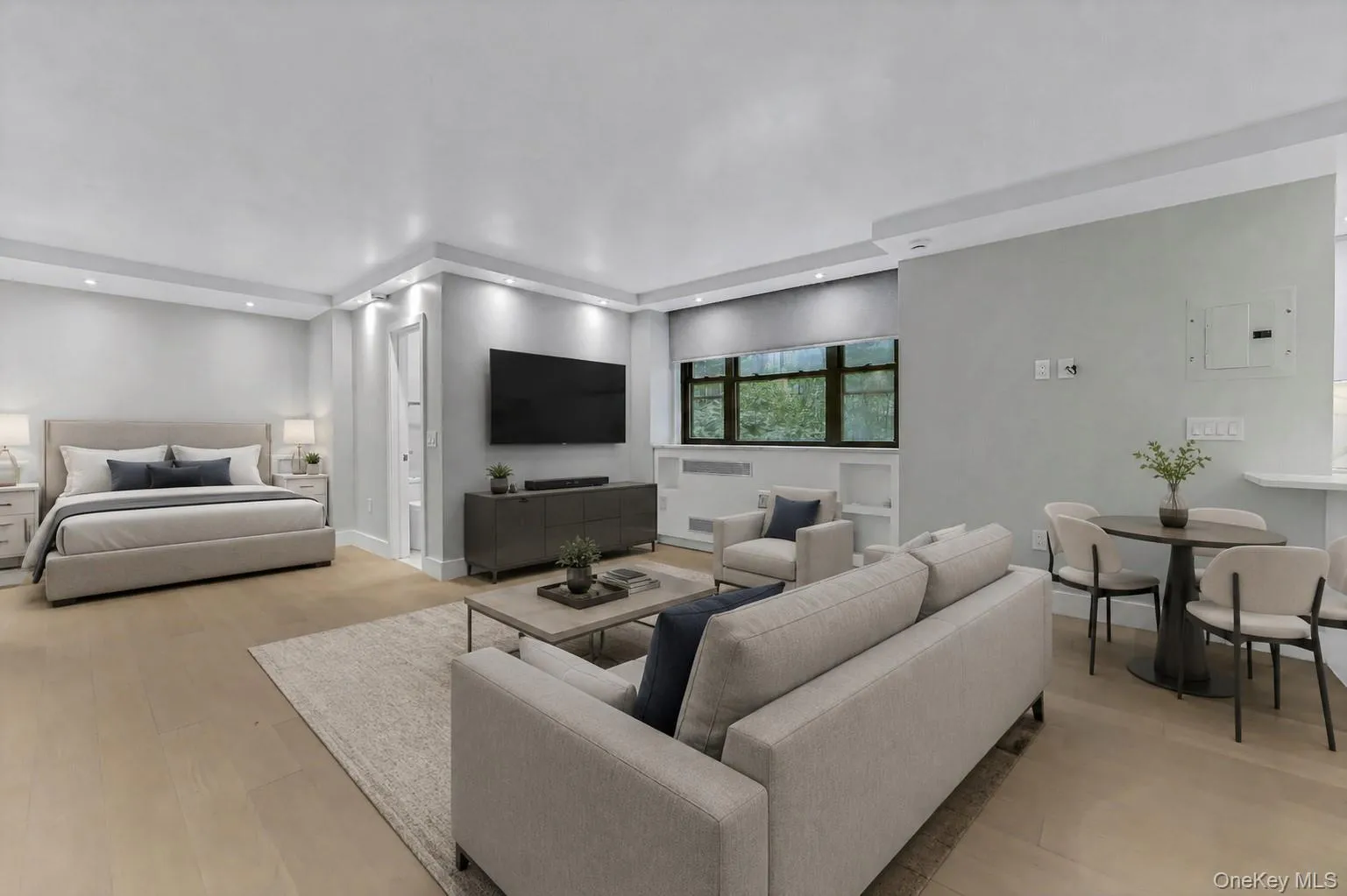 Open-concept living space with light wood-finish flooring, recessed lighting, and a large window Open-concept living space with light wood-finish flooring, recessed lighting, and a large window