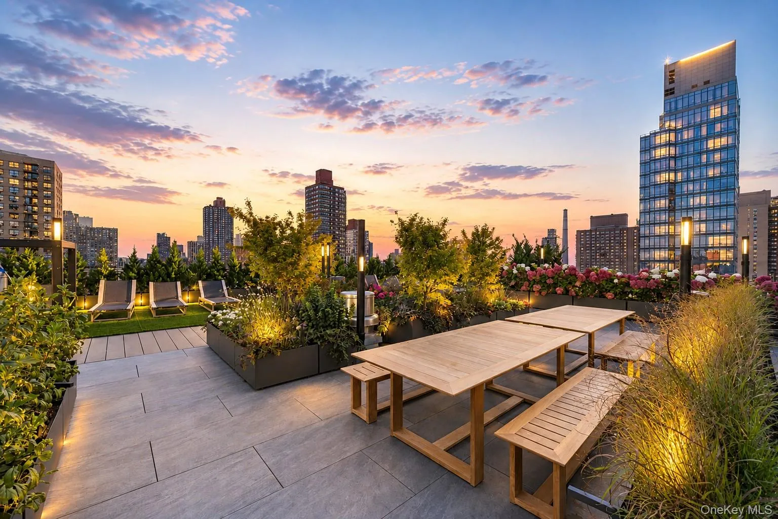 Rooftop patio with paver flooring, multiple seating areas, built-in planters with diverse plantings, and integrated accent lighting Rooftop patio with paver flooring, multiple seating areas, built-in planters with diverse plantings, and integrated accent lighting