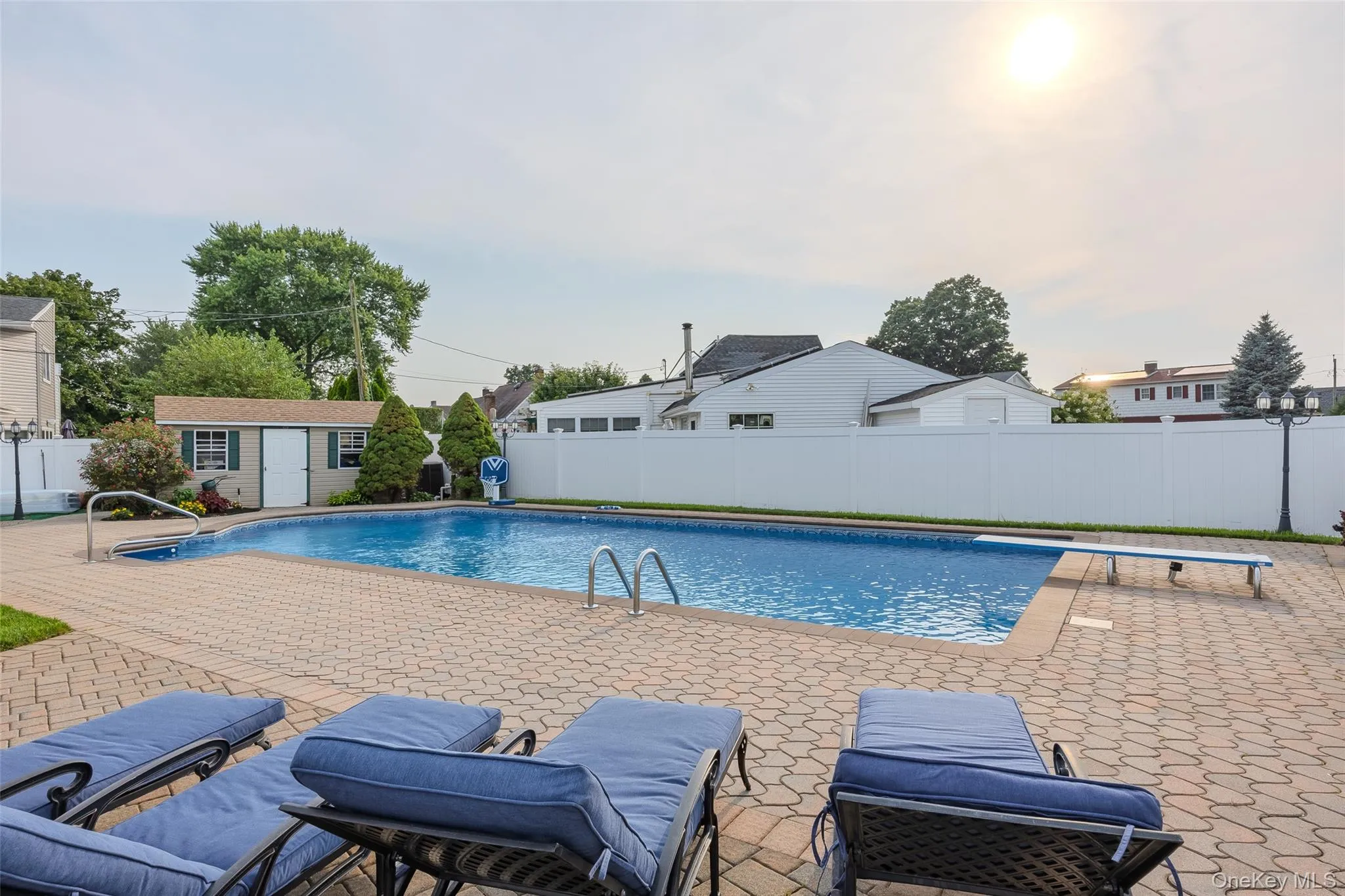 View of pool with a fenced backyard, a patio, a diving board, and an outdoor structure View of pool with a fenced backyard, a patio, a diving board, and an outdoor structure