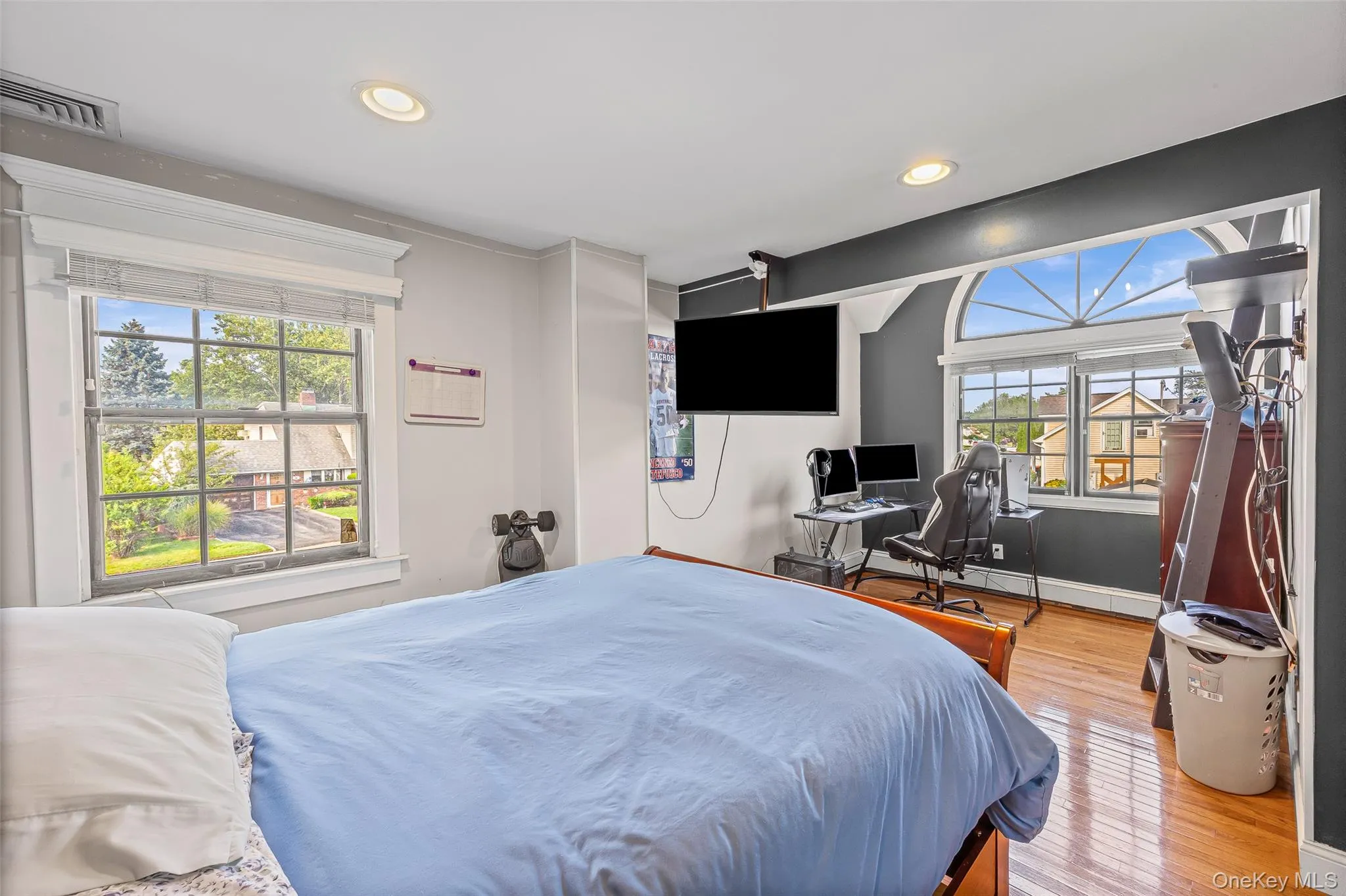 Bedroom with an office area, light wood-style flooring, and recessed lighting Bedroom with an office area, light wood-style flooring, and recessed lighting