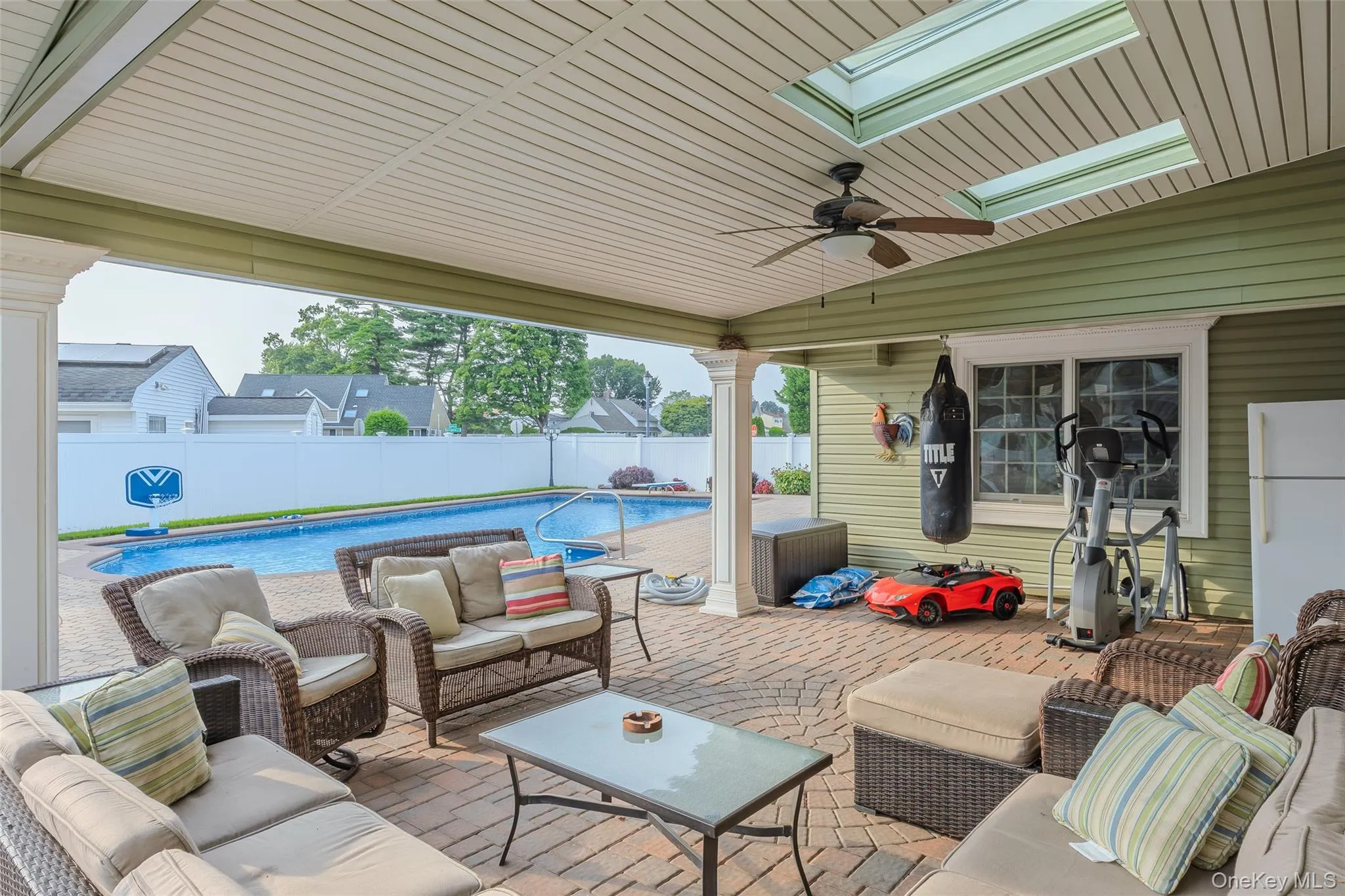 Fenced backyard with outdoor lounge area, a patio, and a ceiling fan Fenced backyard with outdoor lounge area, a patio, and a ceiling fan