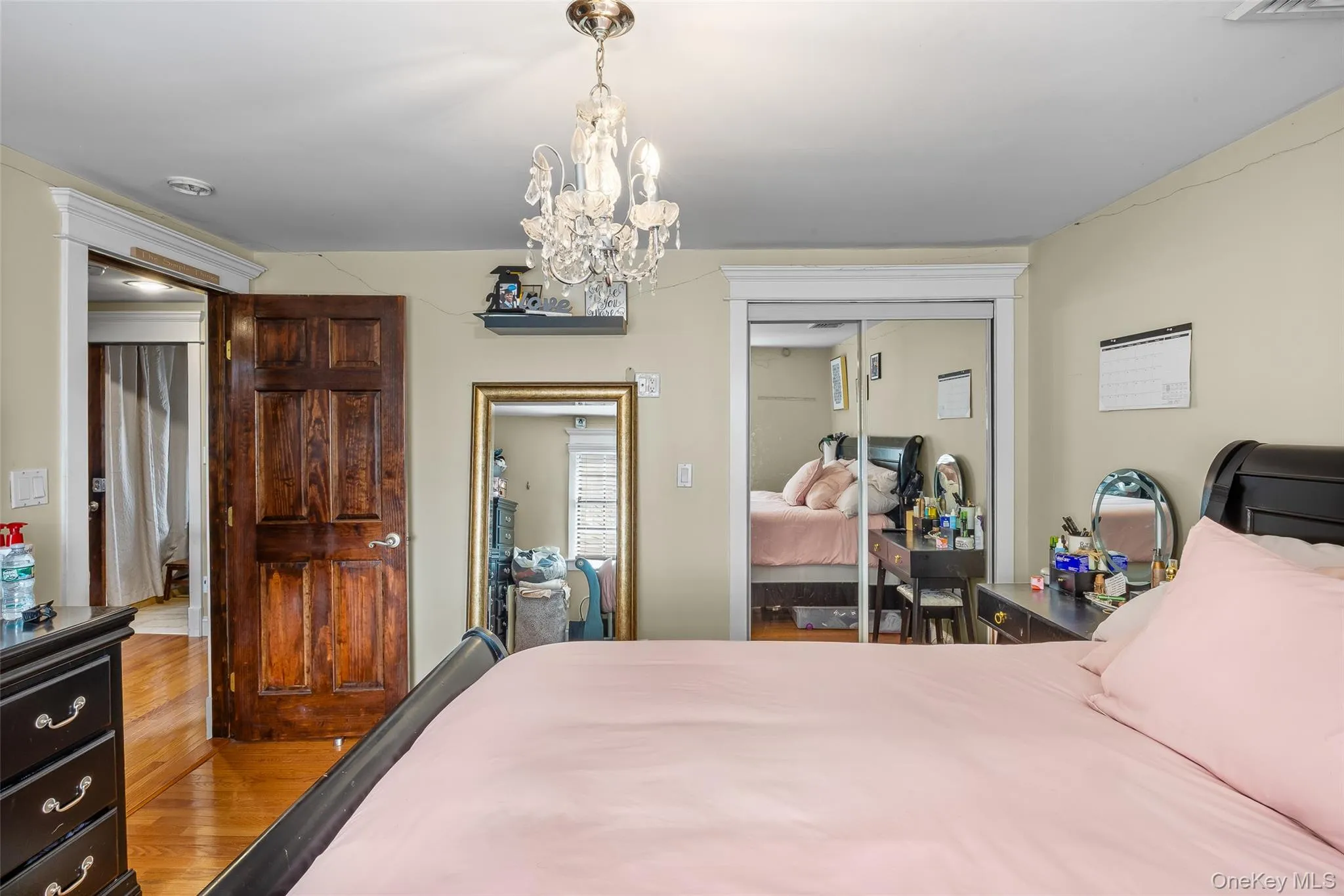 Bedroom with wood finished floors, a closet, and a chandelier Bedroom with wood finished floors, a closet, and a chandelier