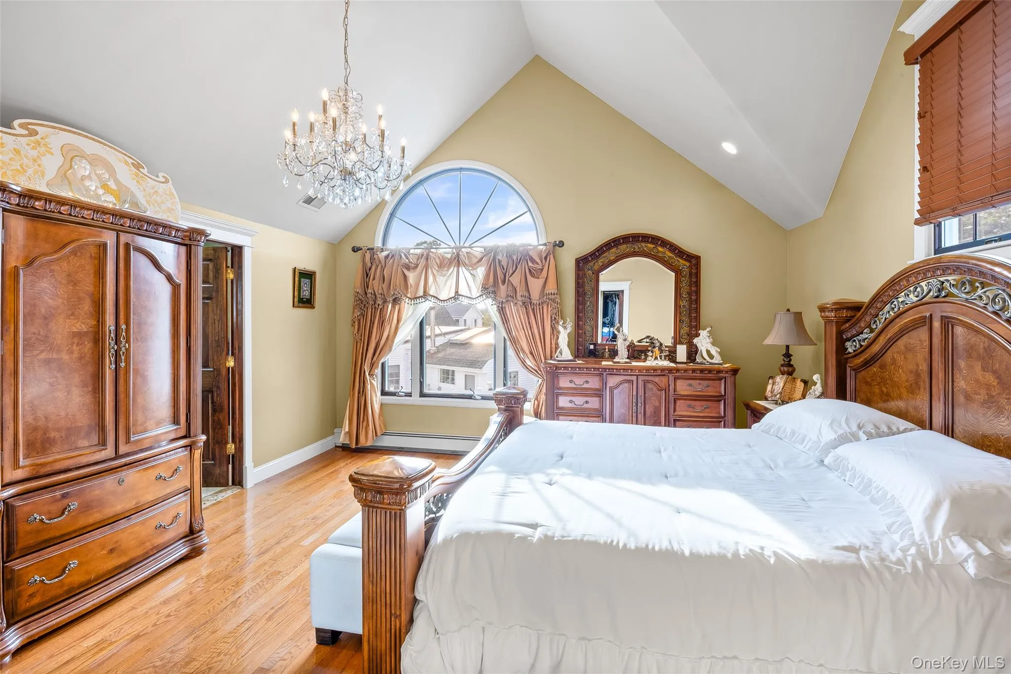 Bedroom with light wood-type flooring, high vaulted ceiling, a chandelier, and recessed lighting Bedroom with light wood-type flooring, high vaulted ceiling, a chandelier, and recessed lighting