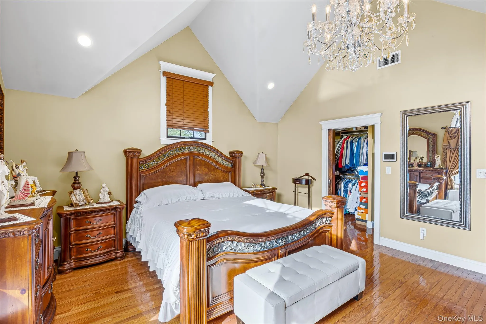 Bedroom featuring light wood-style floors, a spacious closet, recessed lighting, a chandelier, and lofted ceiling Bedroom featuring light wood-style floors, a spacious closet, recessed lighting, a chandelier, and lofted ceiling