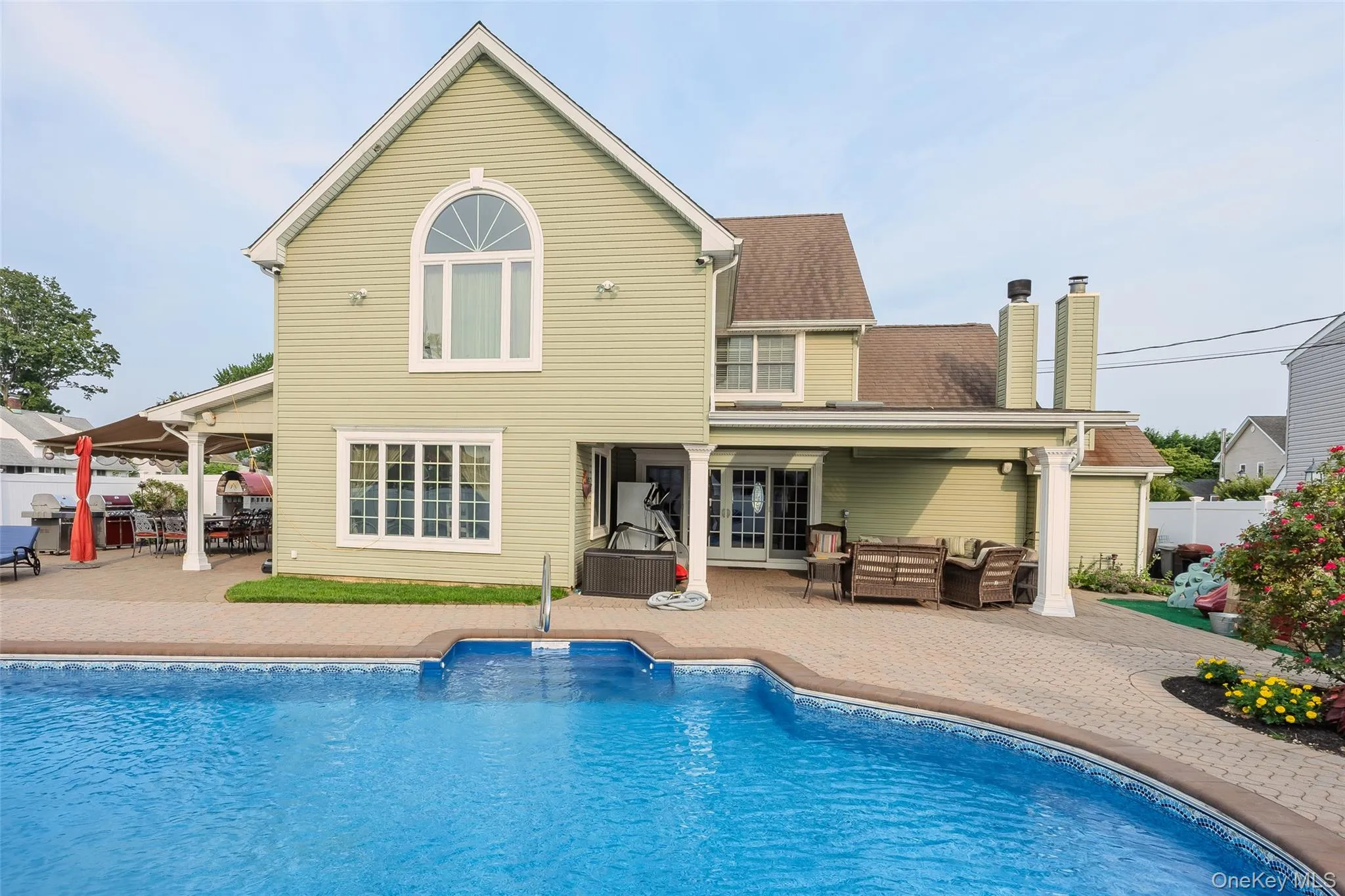 Back of house featuring a patio, outdoor lounge area, and a chimney Back of house featuring a patio, outdoor lounge area, and a chimney