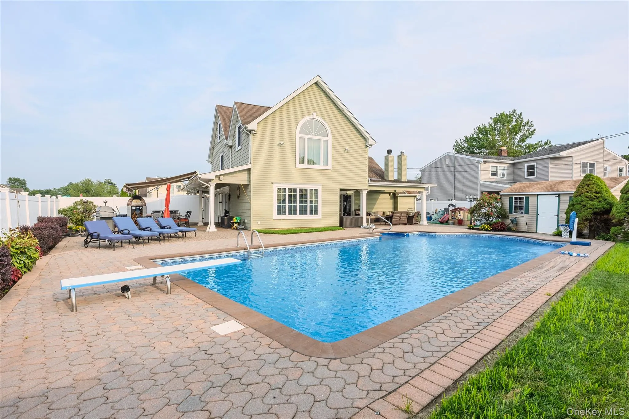 View of swimming pool with a patio, a fenced backyard, an outbuilding, and a diving board View of swimming pool with a patio, a fenced backyard, an outbuilding, and a diving board