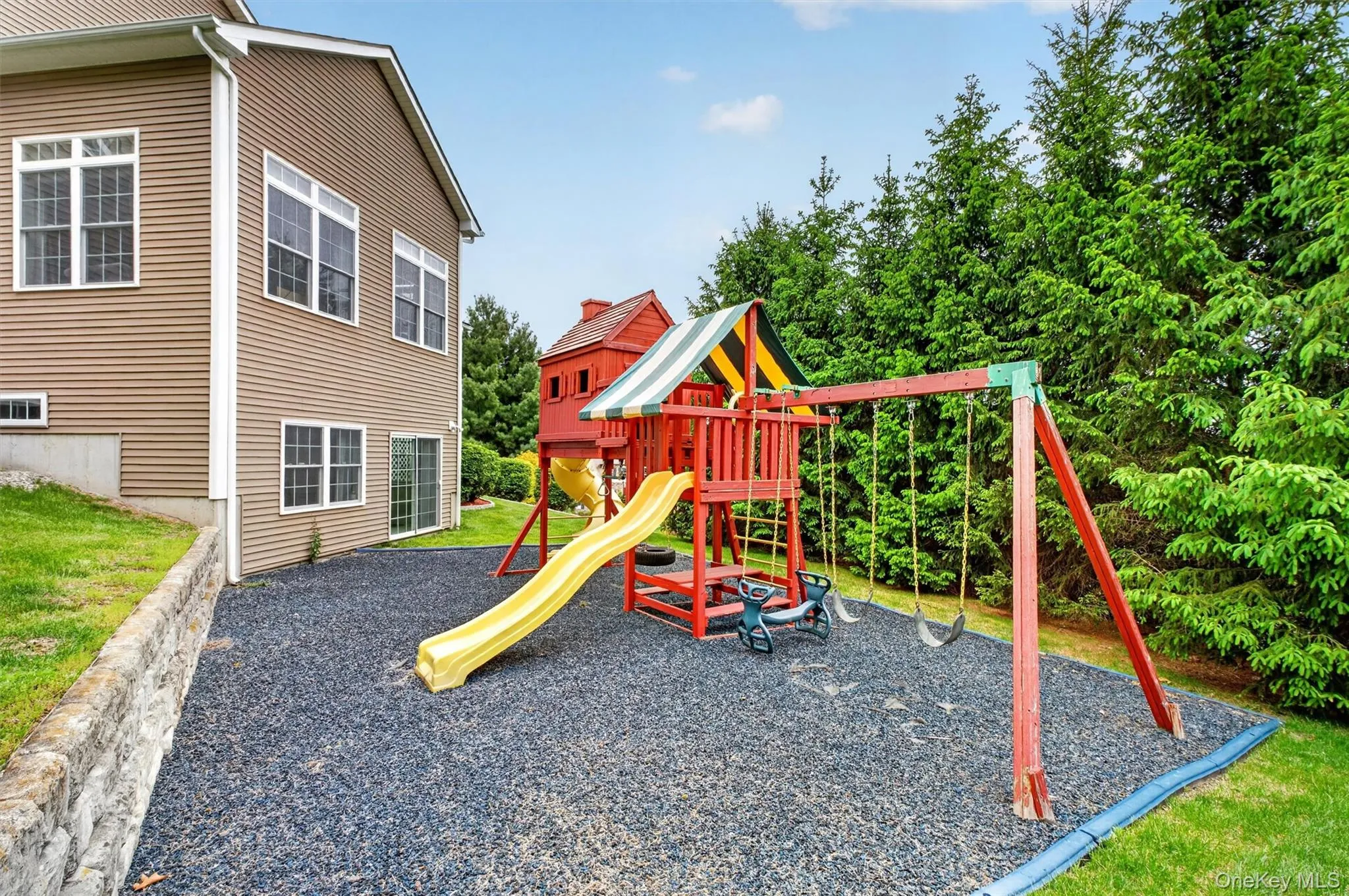 Large backyard play area with upgraded treehouse-style playset and premium rubber mulch surface. Large backyard play area with upgraded treehouse-style playset and premium rubber mulch surface.