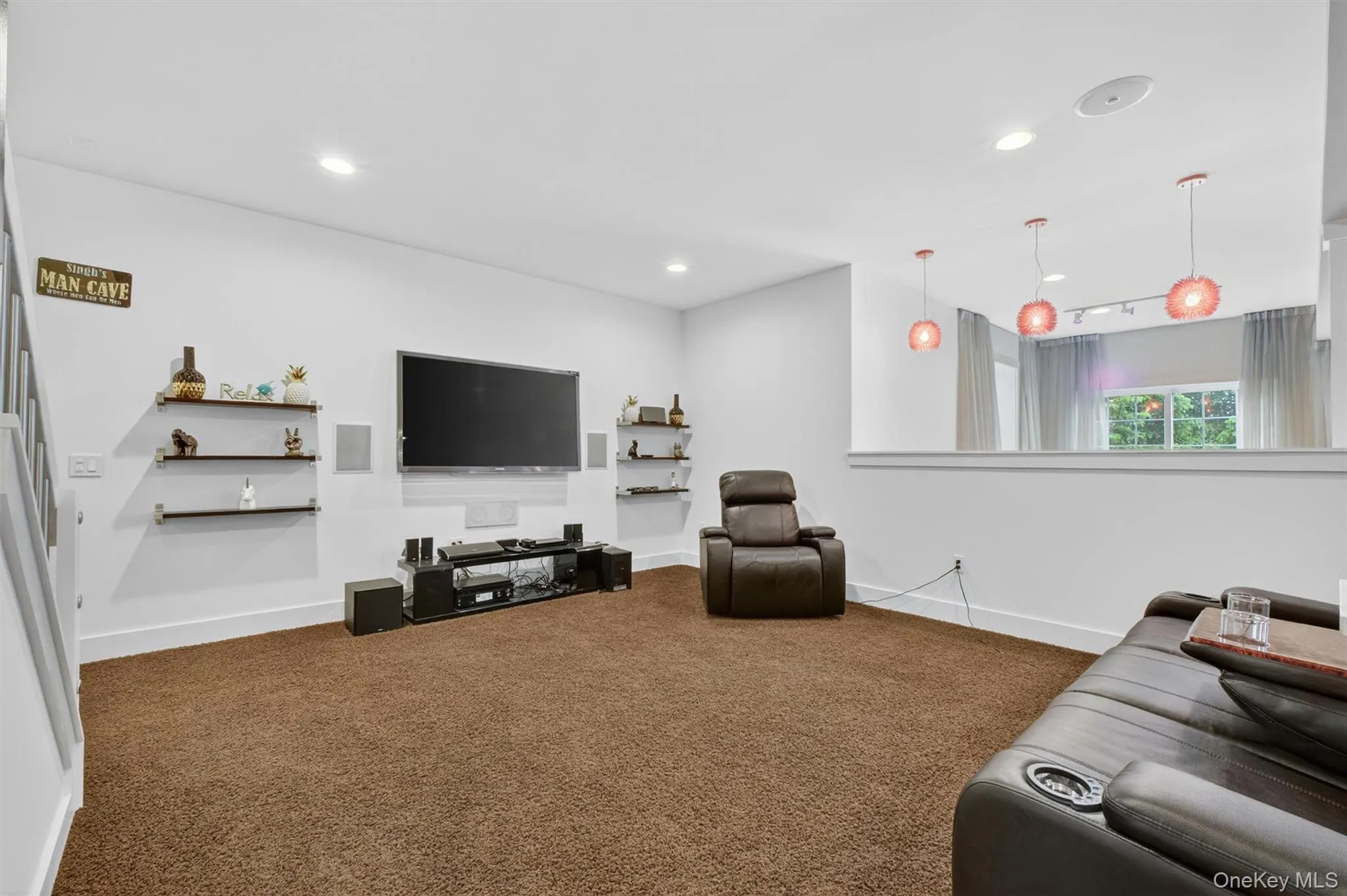 Lower-level media room with built-in surround sound and spacious entertainment layout. Lower-level media room with built-in surround sound and spacious entertainment layout.