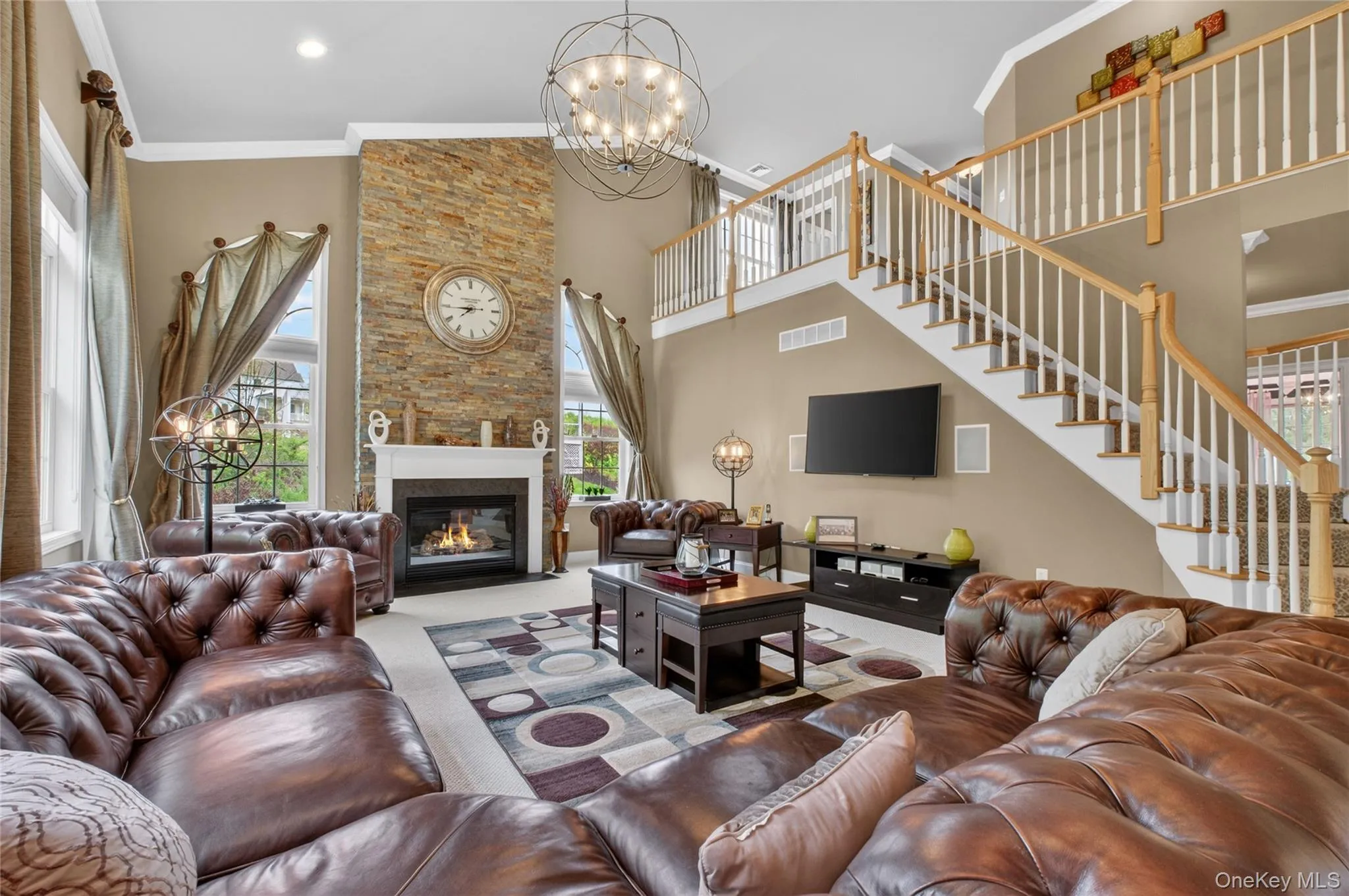 Dramatic great room with soaring ceilings, gas fireplace, built-in surround speakers, and open-concept flow. Dramatic great room with soaring ceilings, gas fireplace, built-in surround speakers, and open-concept flow.